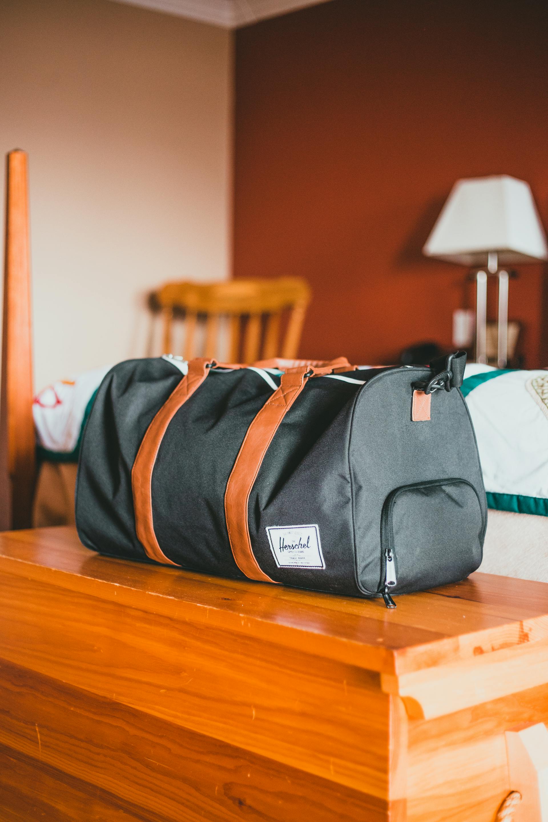 Un sac de voyage posé sur une table en bois | Source : Pexels