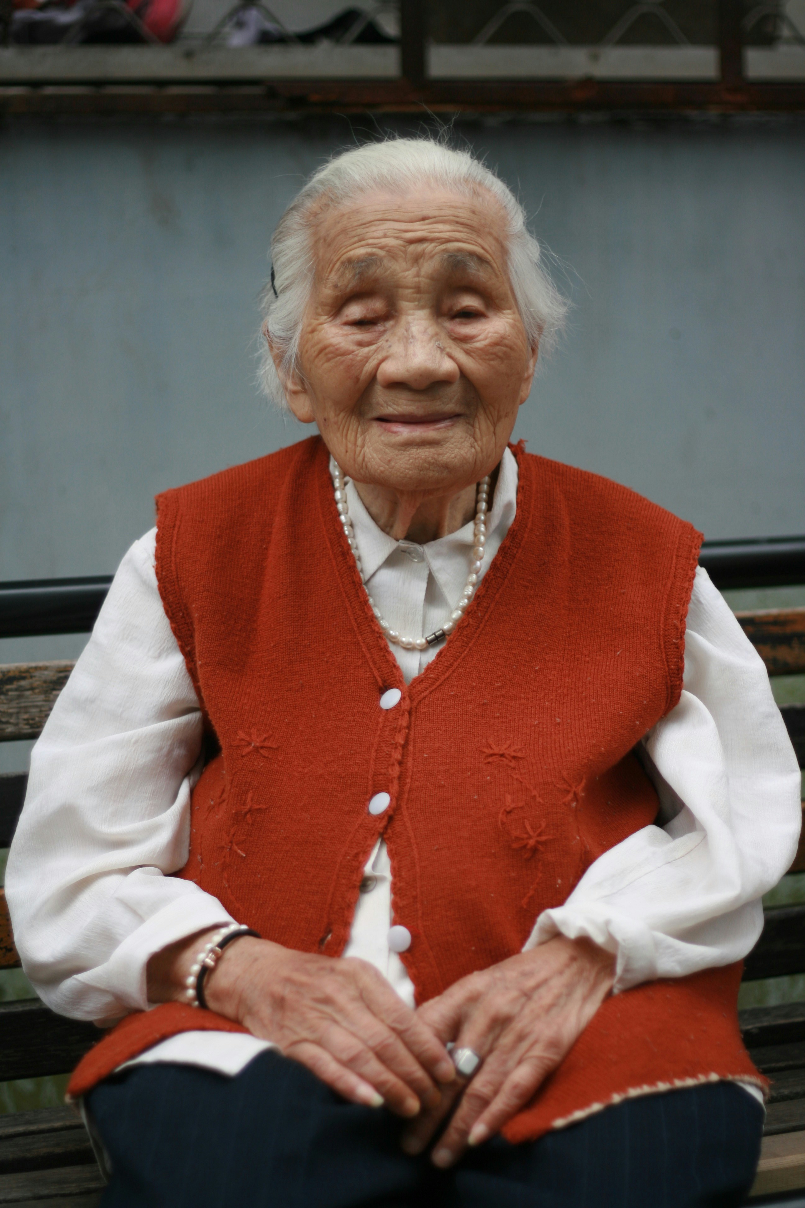 Une vieille femme portant un gilet rouge | Source : Unsplash