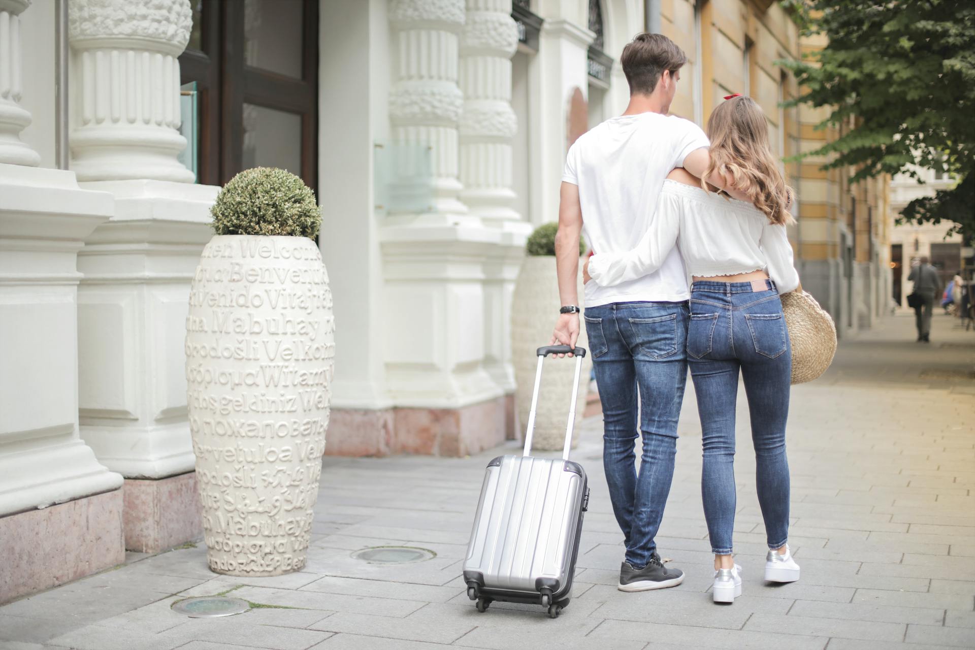 Un couple marchant dans la rue avec ses bagages | Source : Pexels