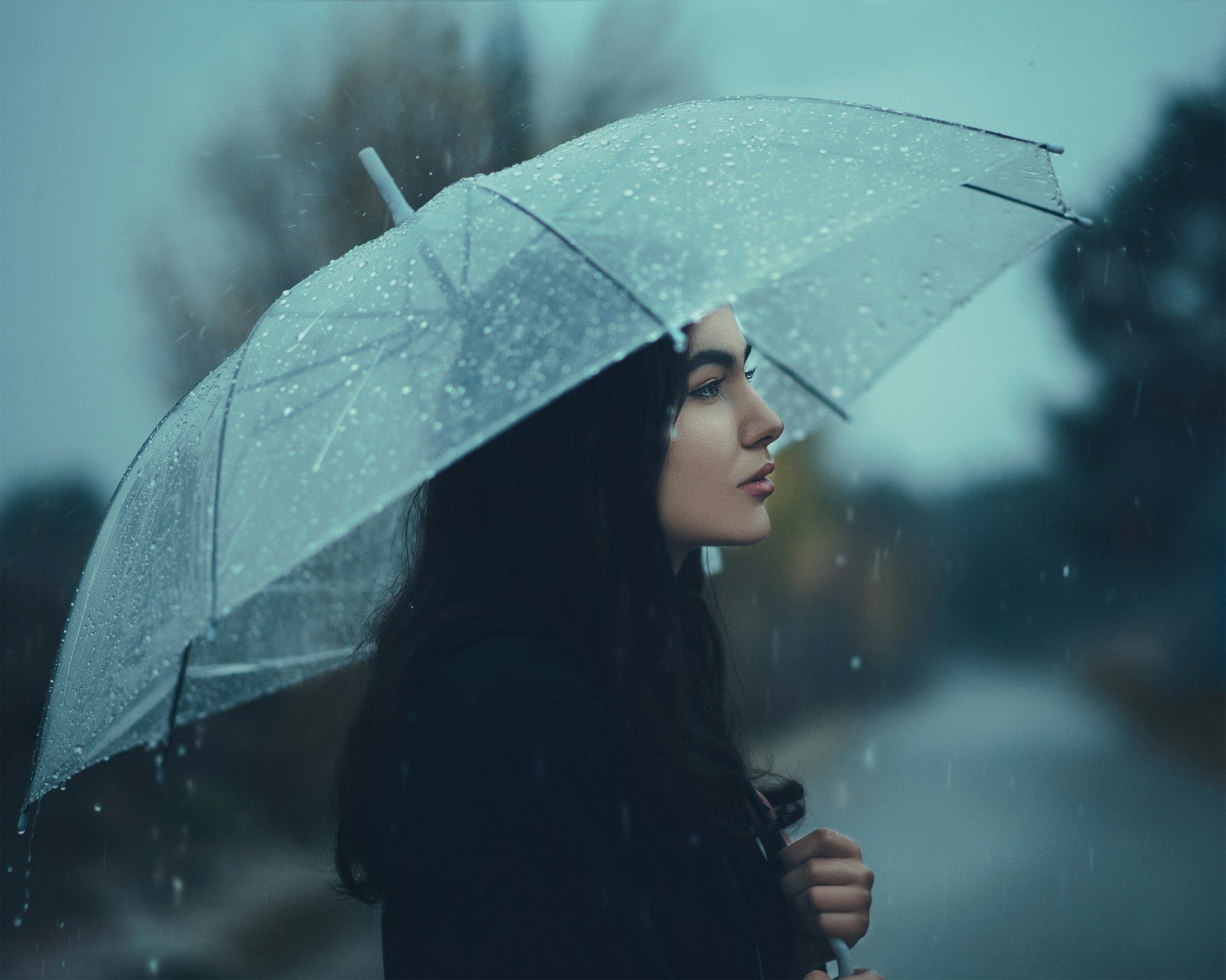 Une femme debout sous la pluie avec un parapluie | Source : Unsplash