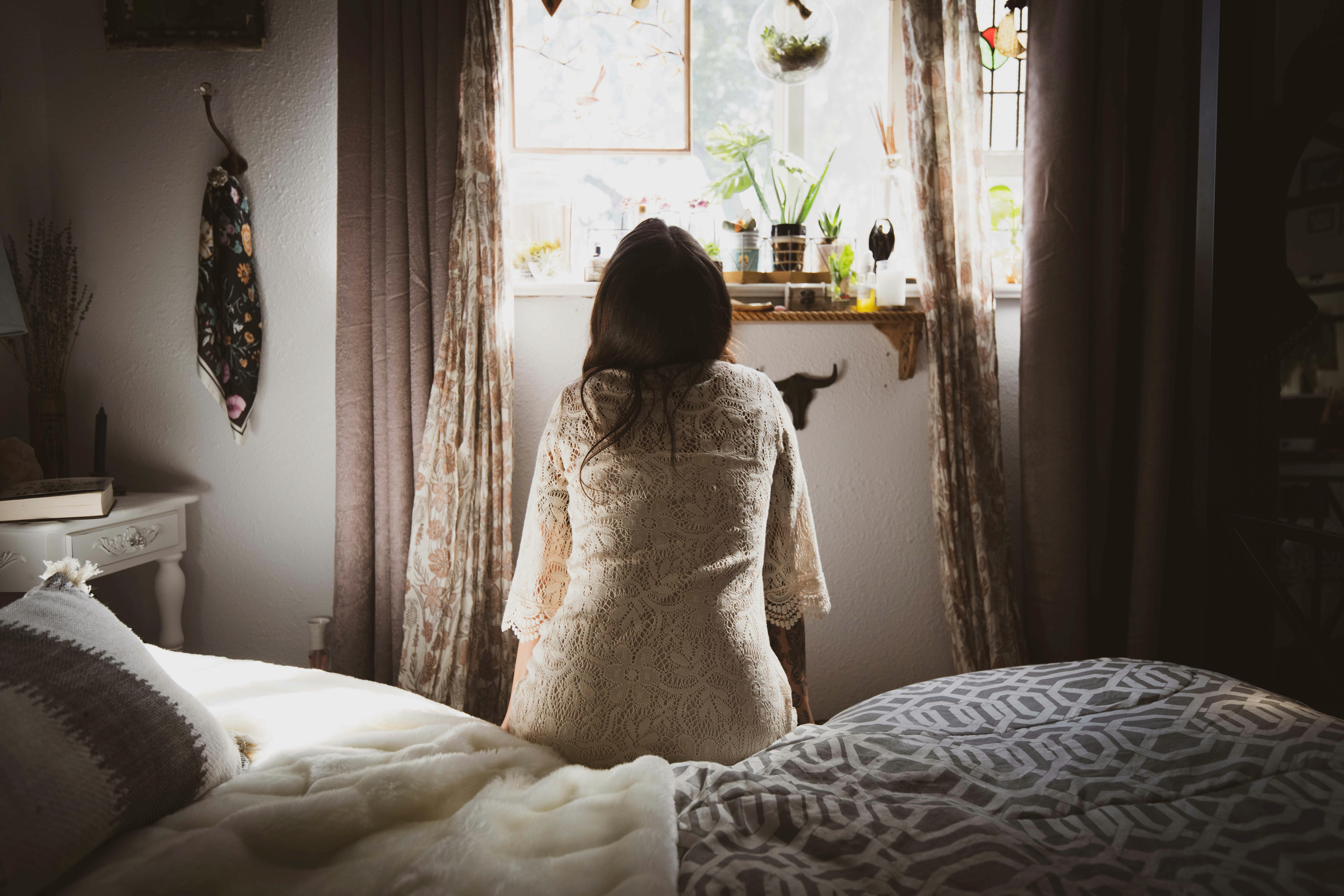Une femme assise sur un lit | Source : Unsplash