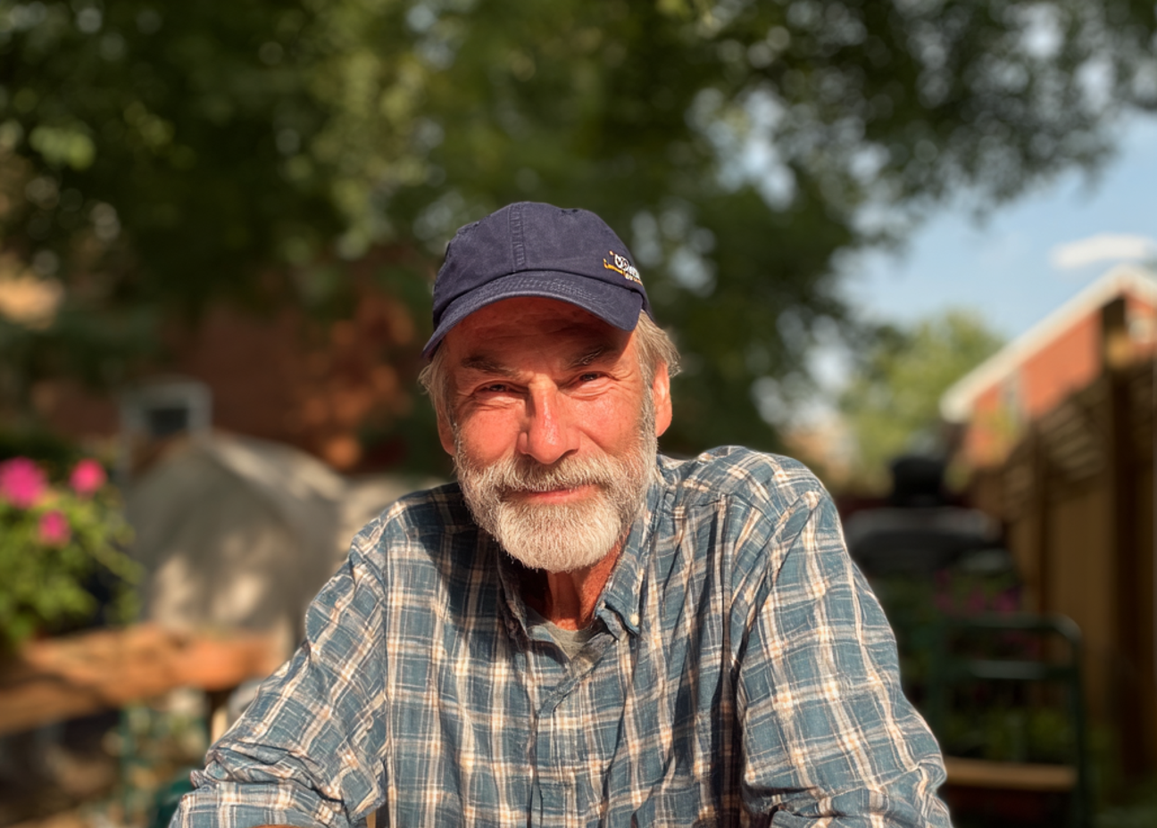 Un homme âgé souriant assis à une table | Source : Midjourney