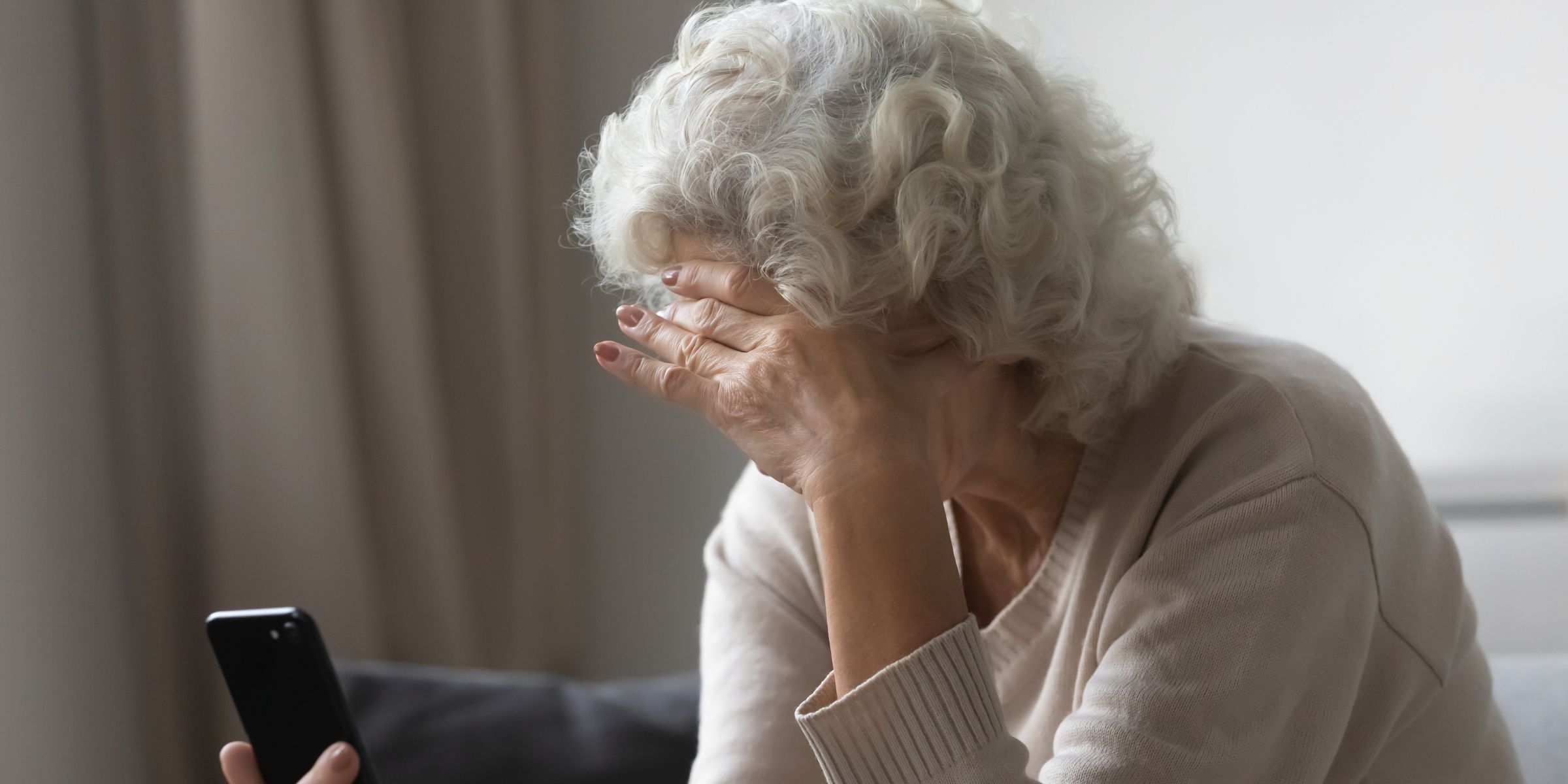 Une femme âgée, l'air frustré, tenant son téléphone | Source : Shutterstock