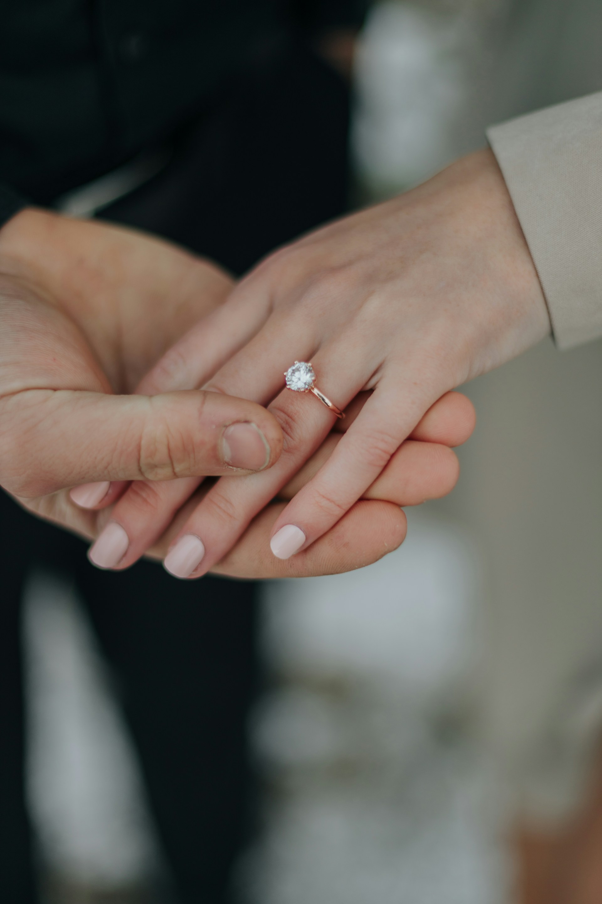 Gros plan d'une femme exhibant sa bague en diamant tout en tenant la main de son partenaire | Source : Unsplash