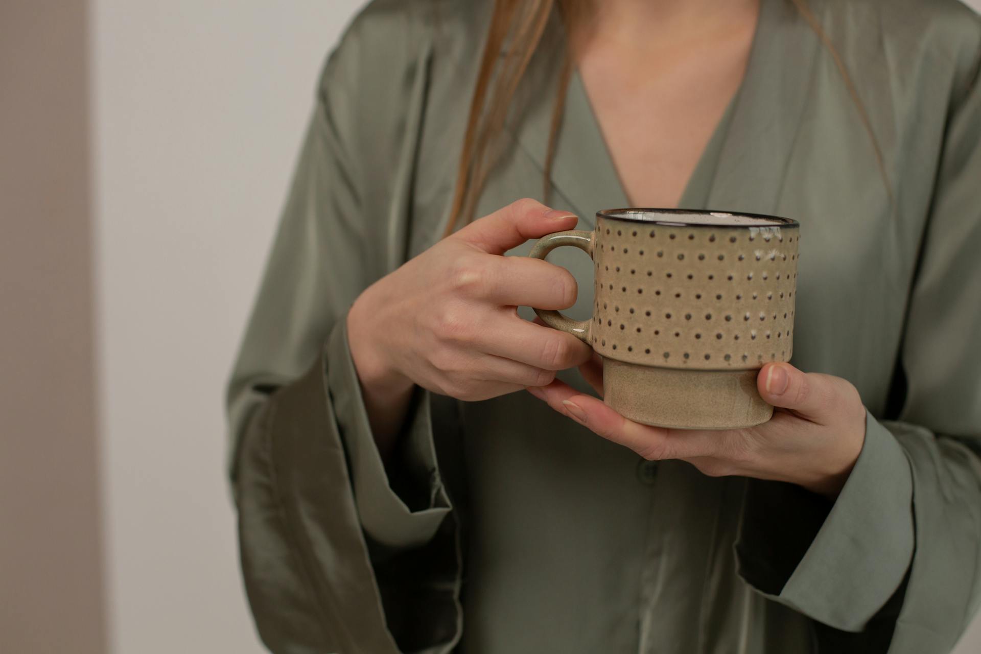 Une femme tenant une tasse en céramique | Source : Pexels