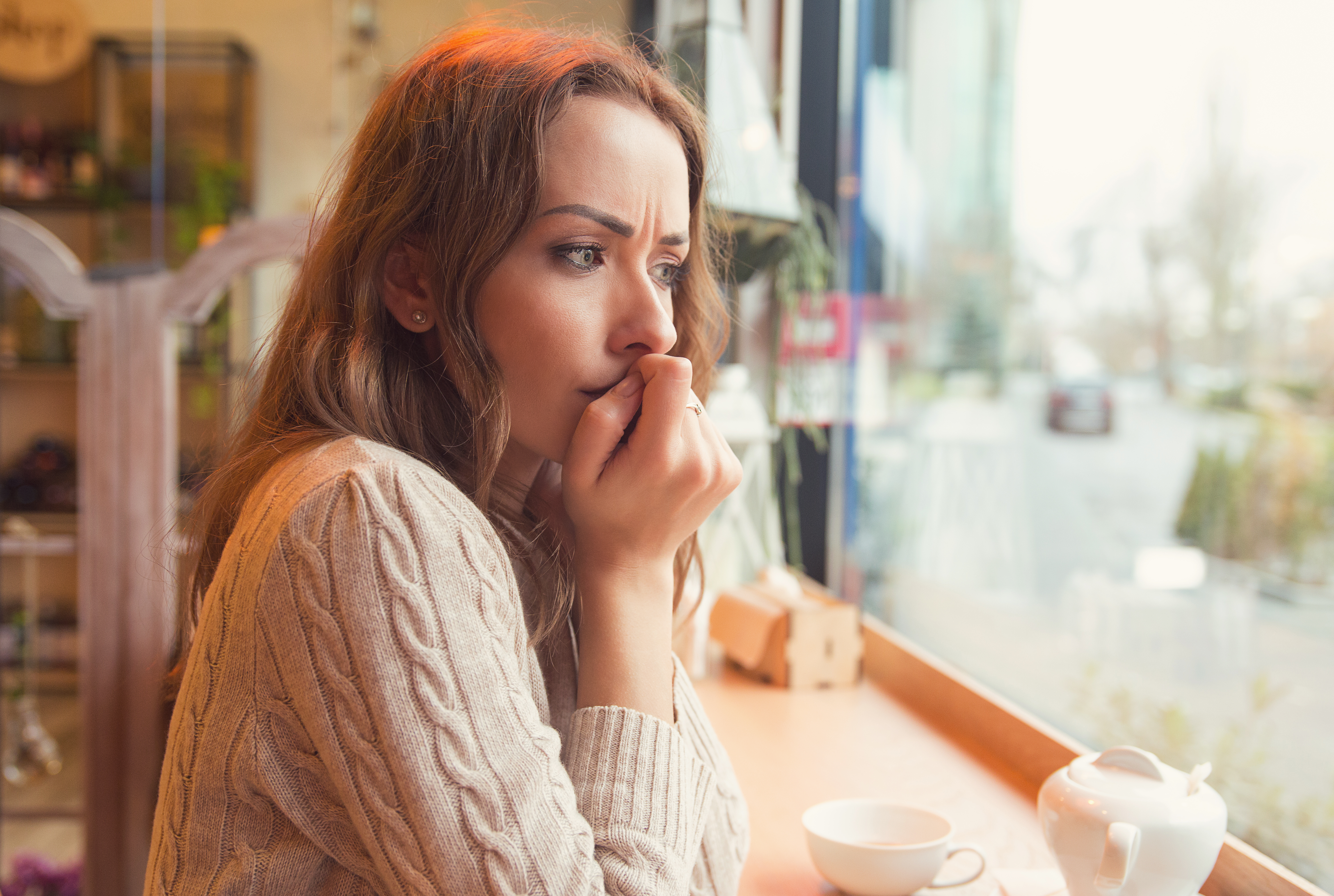 Une jeune femme nerveuse dans un café | Source : Shutterstock