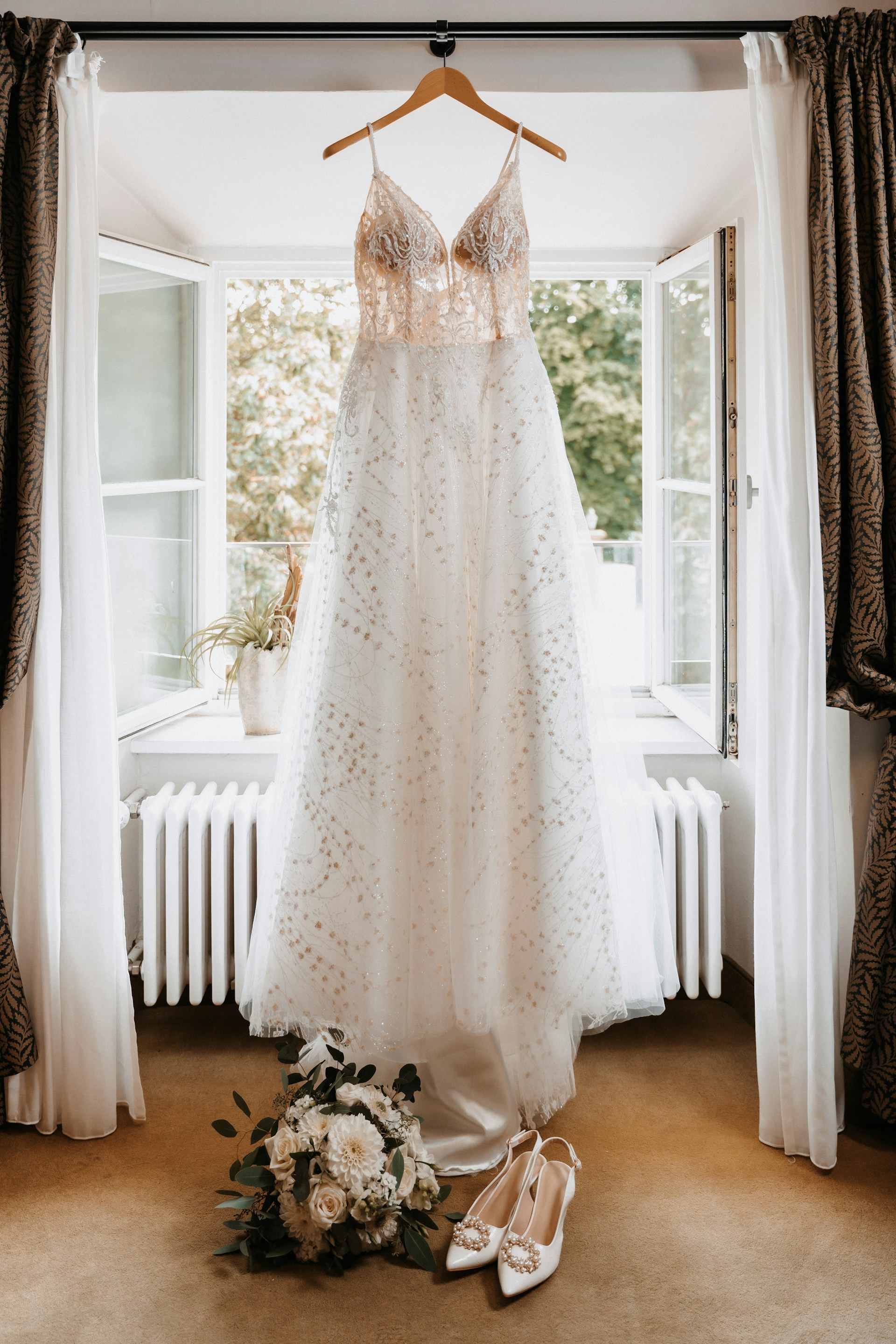 Une robe de mariée et des accessoires près d'une fenêtre | Source : Unsplash