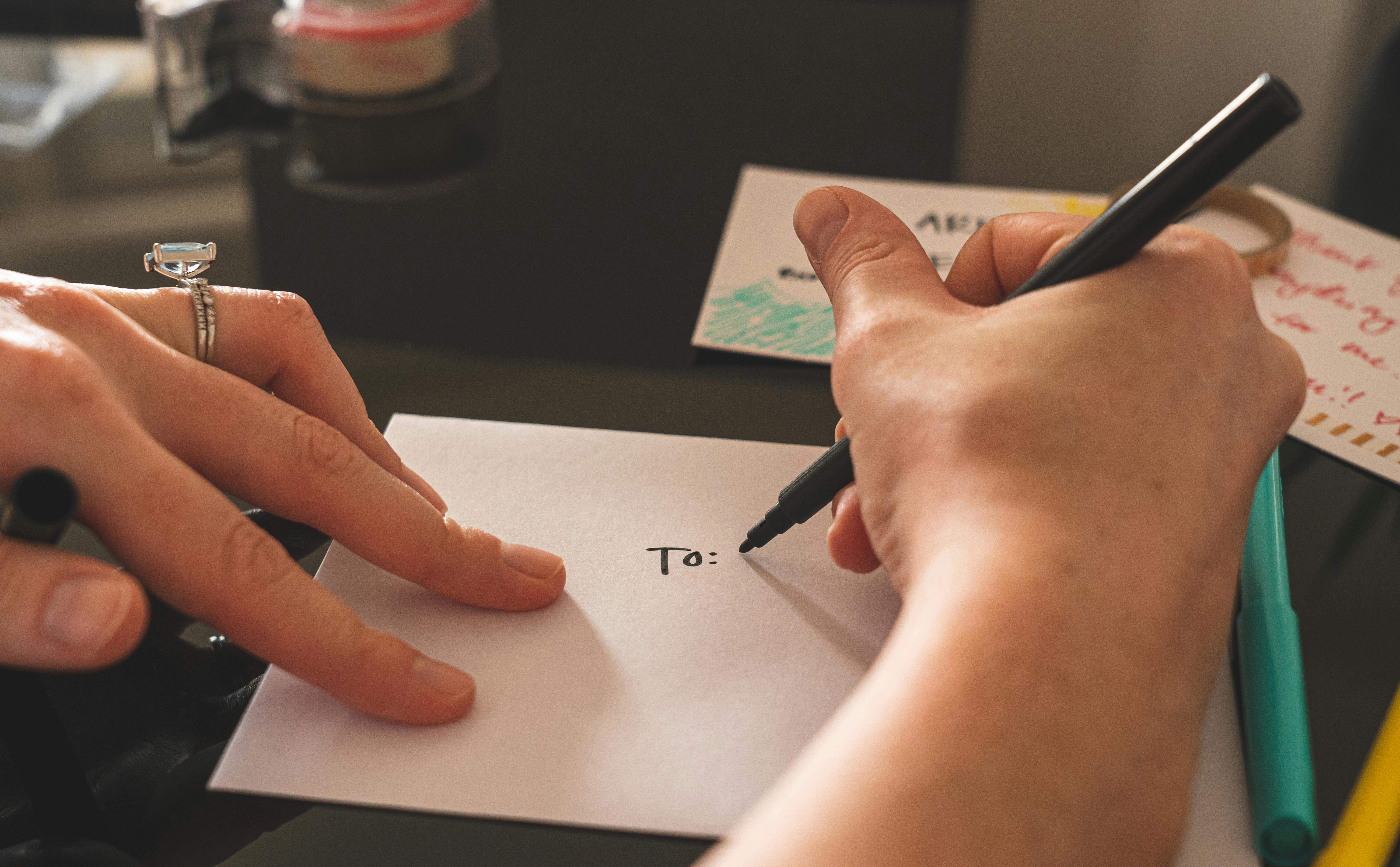 Une femme qui écrit sur une enveloppe | Source : Pexels
