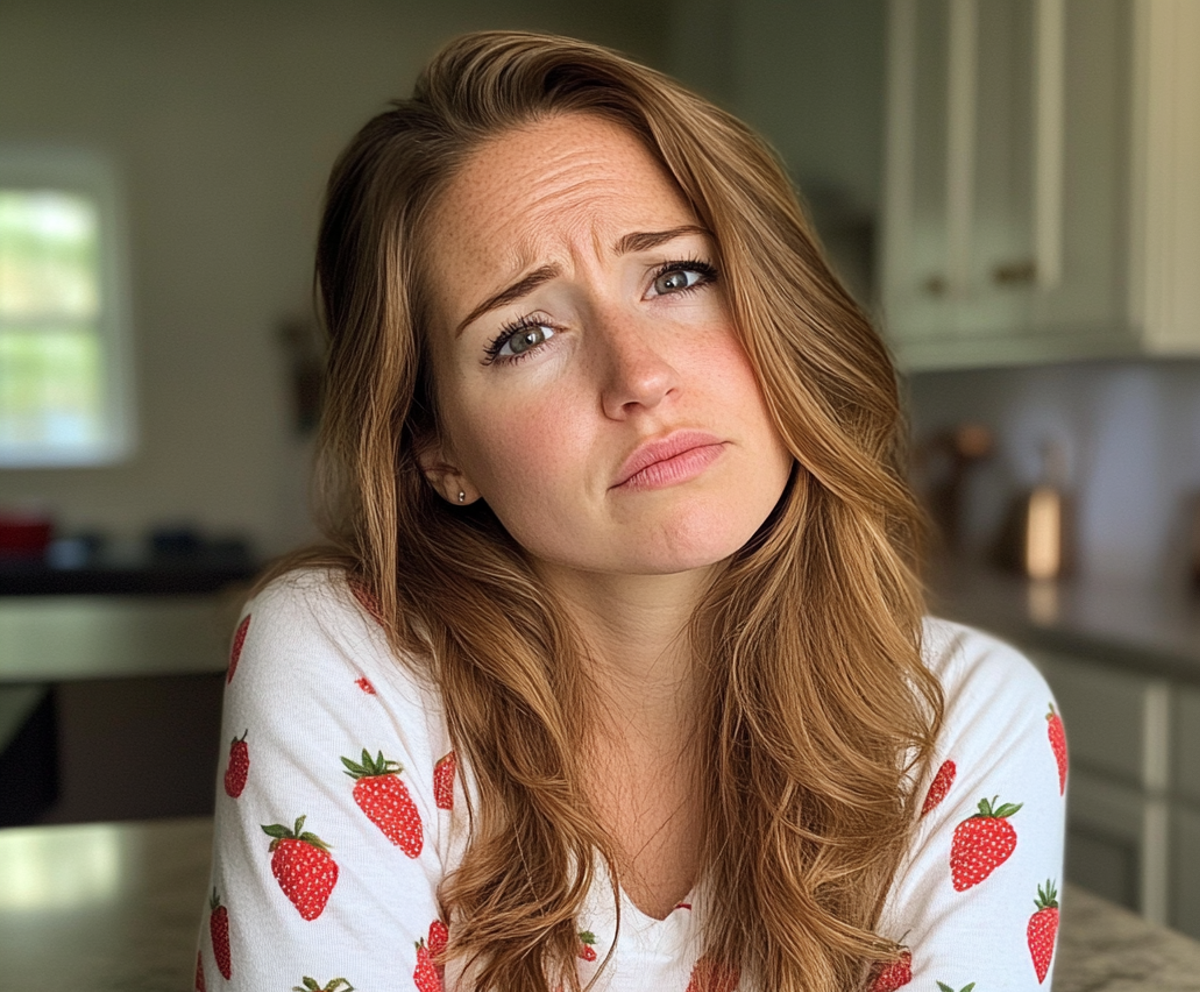 Une femme bouleversée debout dans une cuisine | Source : Midjourney