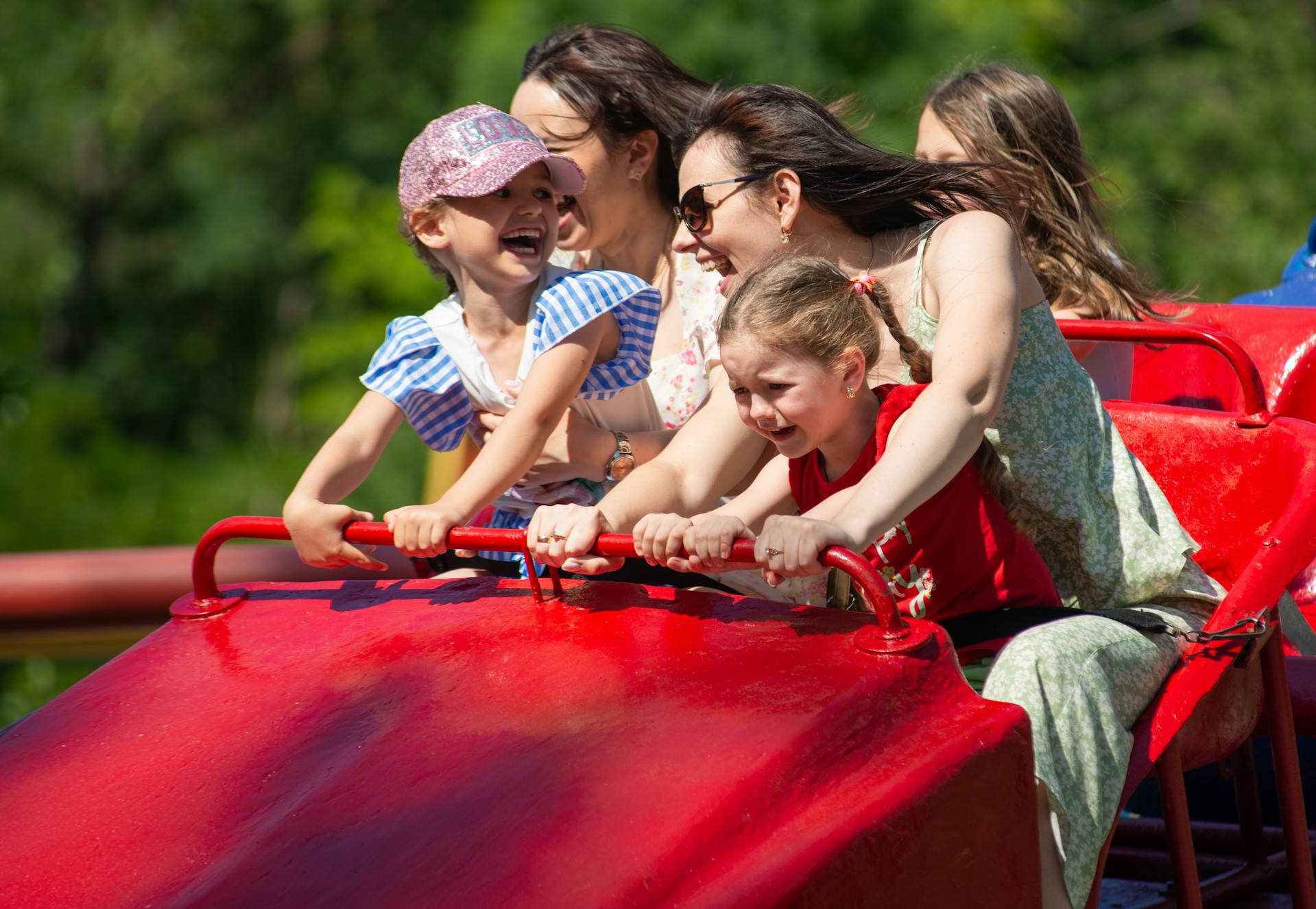 Femmes et enfants sur des montagnes russes dans un parc d'attractions | Source : Pexels