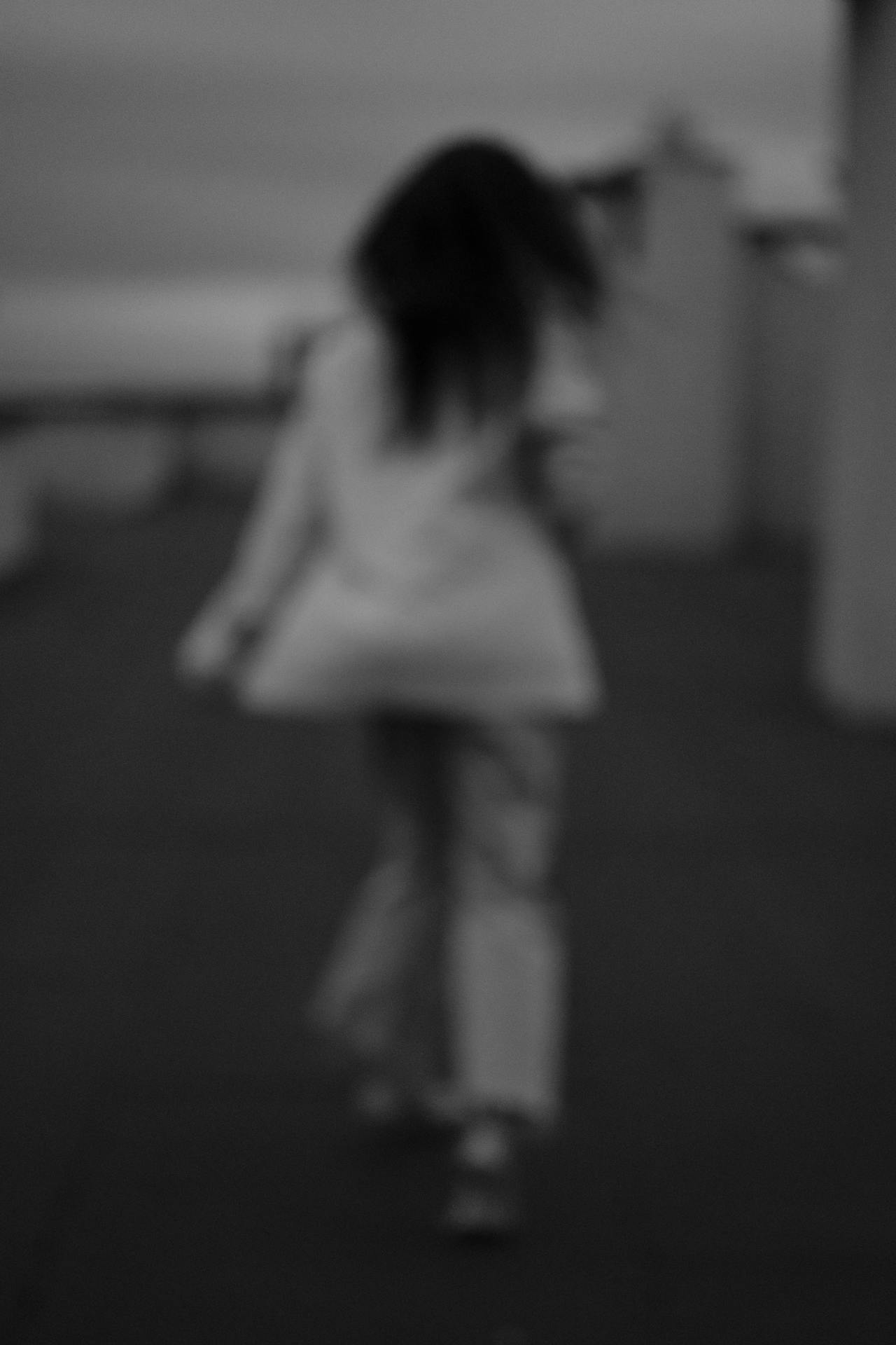 Prise de vue floue en niveaux de gris d'une femme qui s'éloigne | Source : Pexels