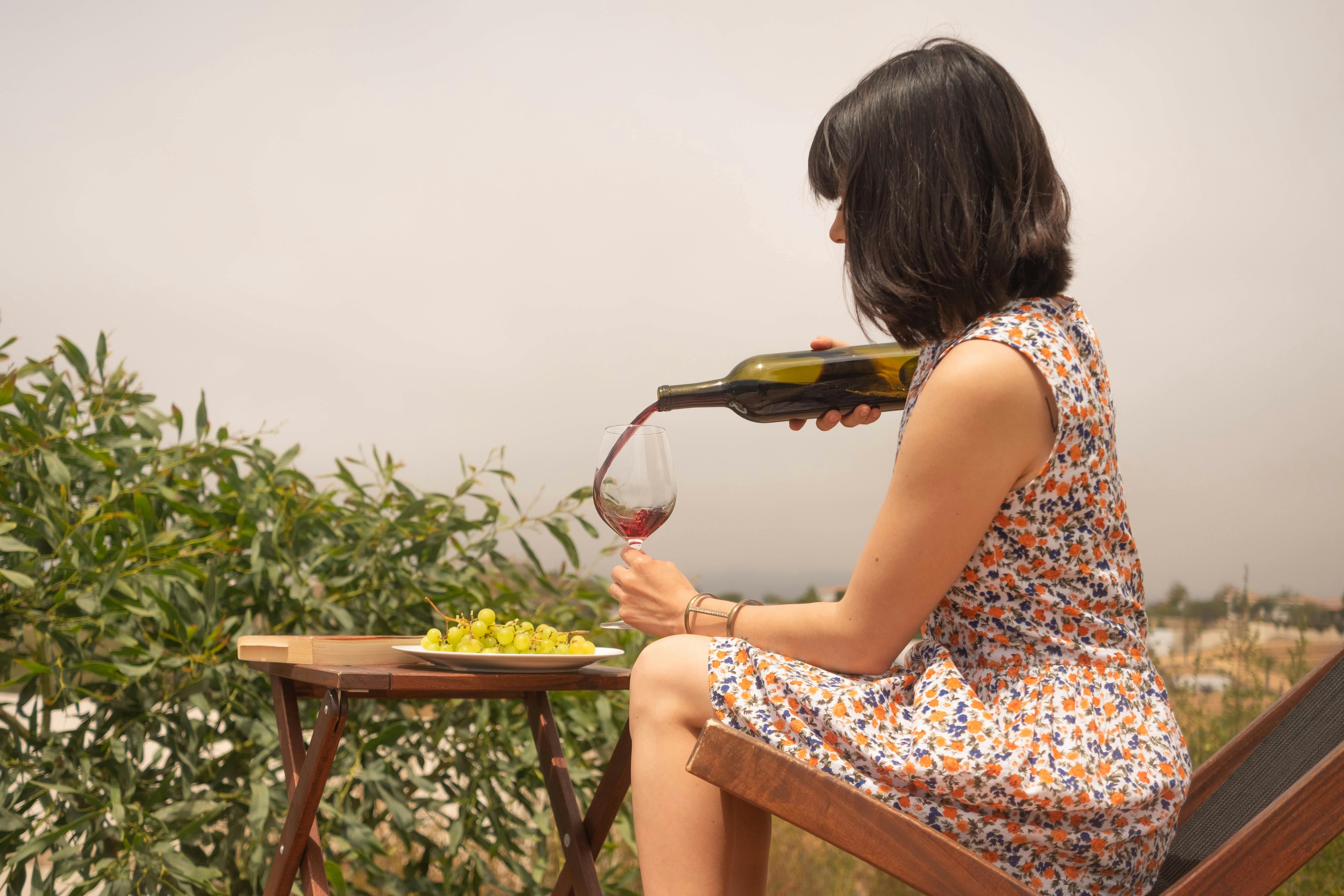Une femme versant du vin dans un verre | Source : Pexels