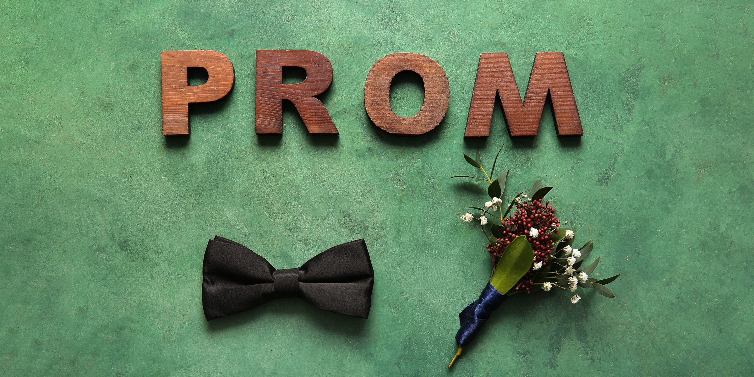 Des lettres épelant le mot "Prom", un nœud papillon et un corsage en boutonnière | Source : Shutterstock