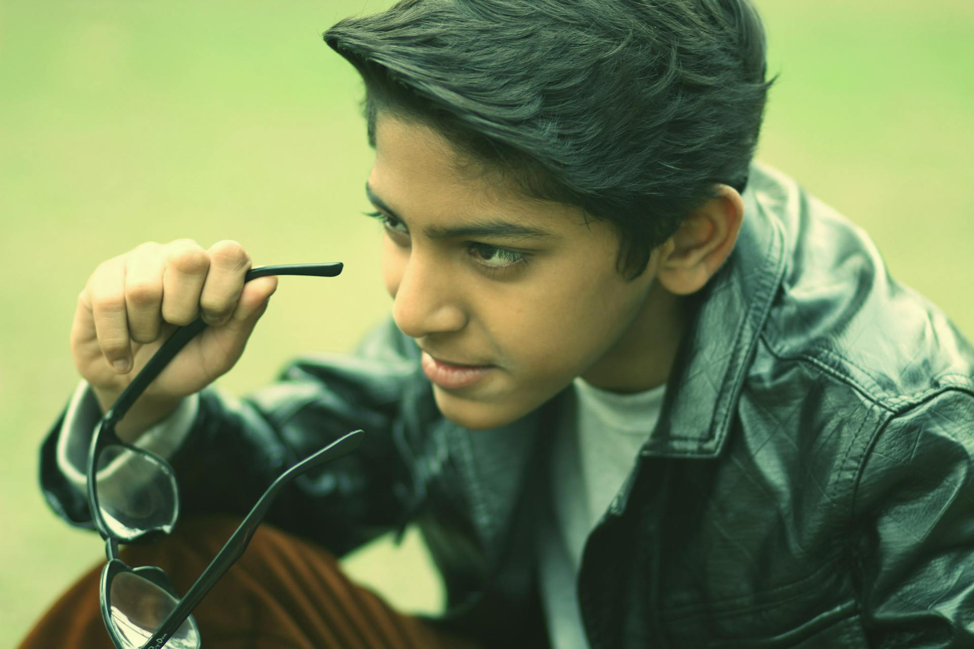 Un adolescent en train d'enlever ses lunettes | Source : Pexels