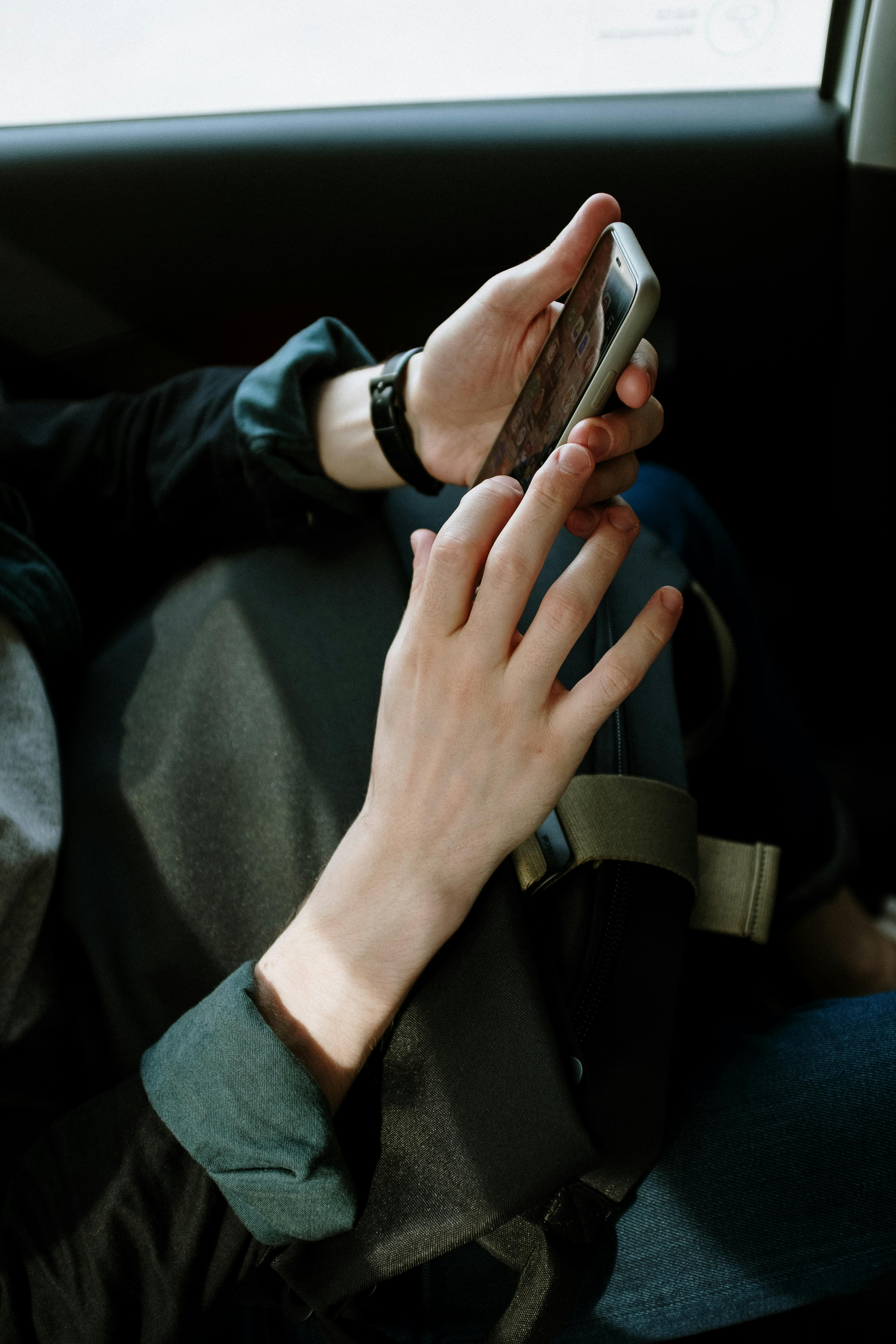 Une personne tenant un téléphone portable dans une voiture | Source : Pexels