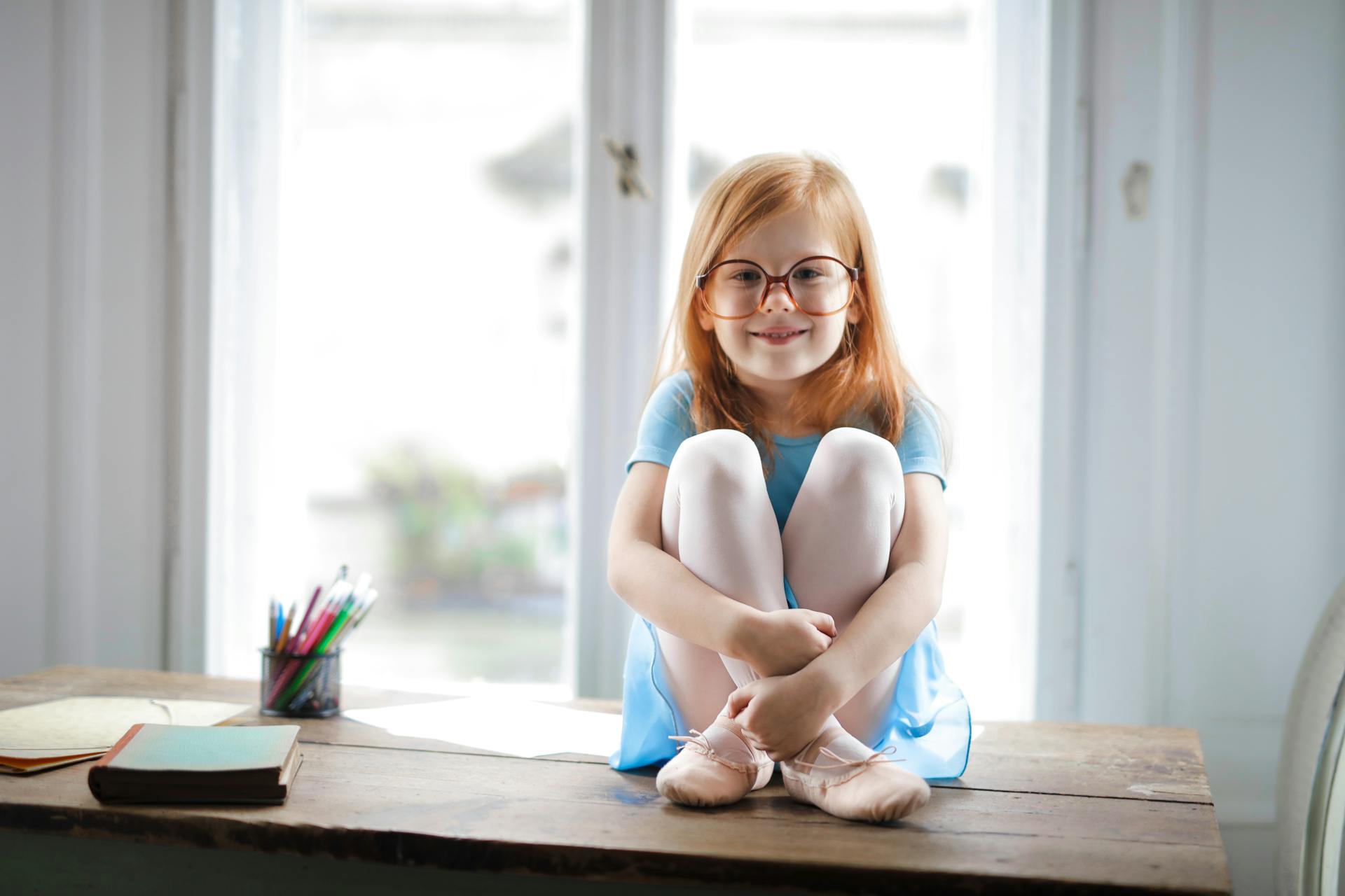 Une petite fille assise sur une table | Source : Pexels