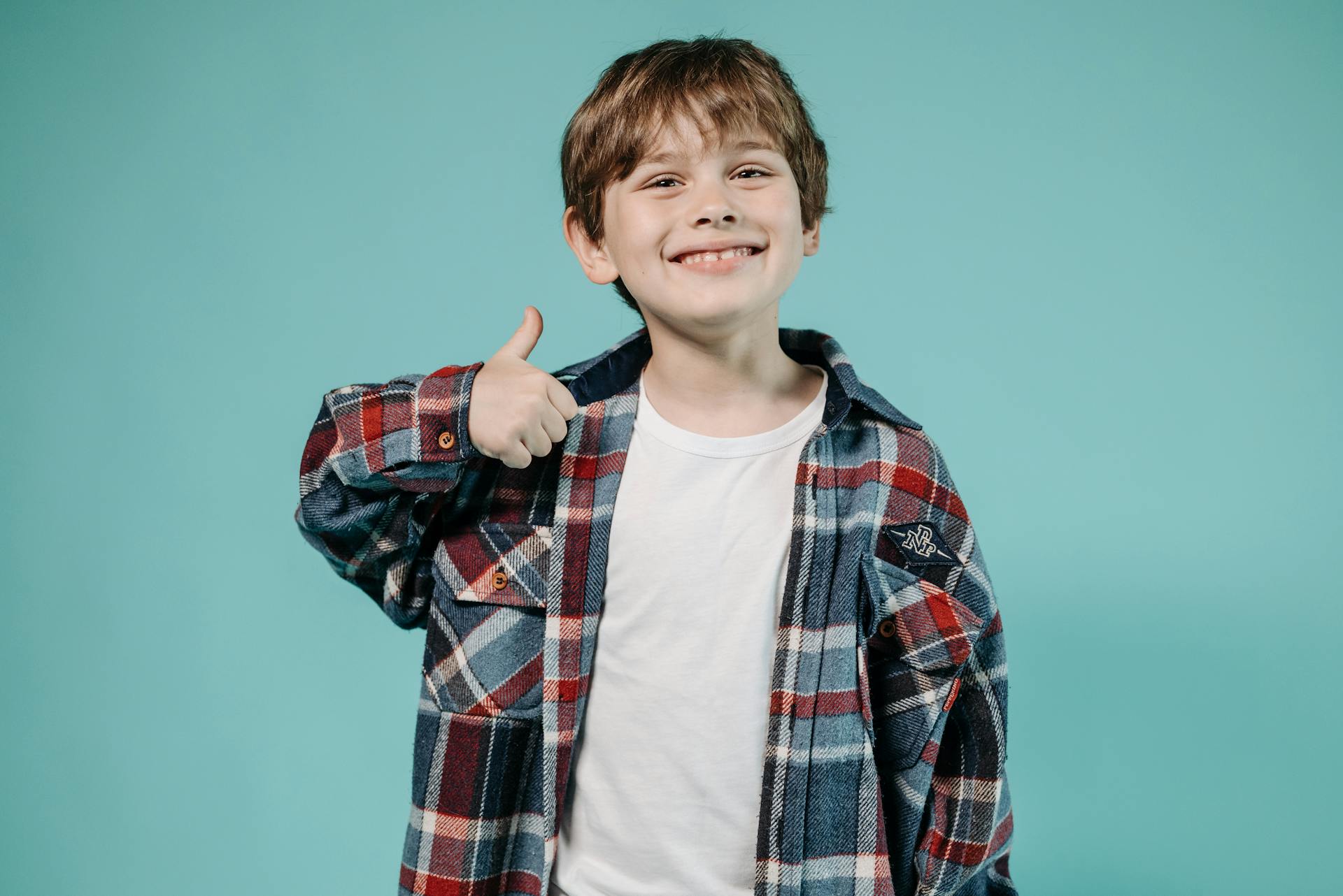 Un garçon heureux qui fait le signe du pouce levé | Source : Pexels