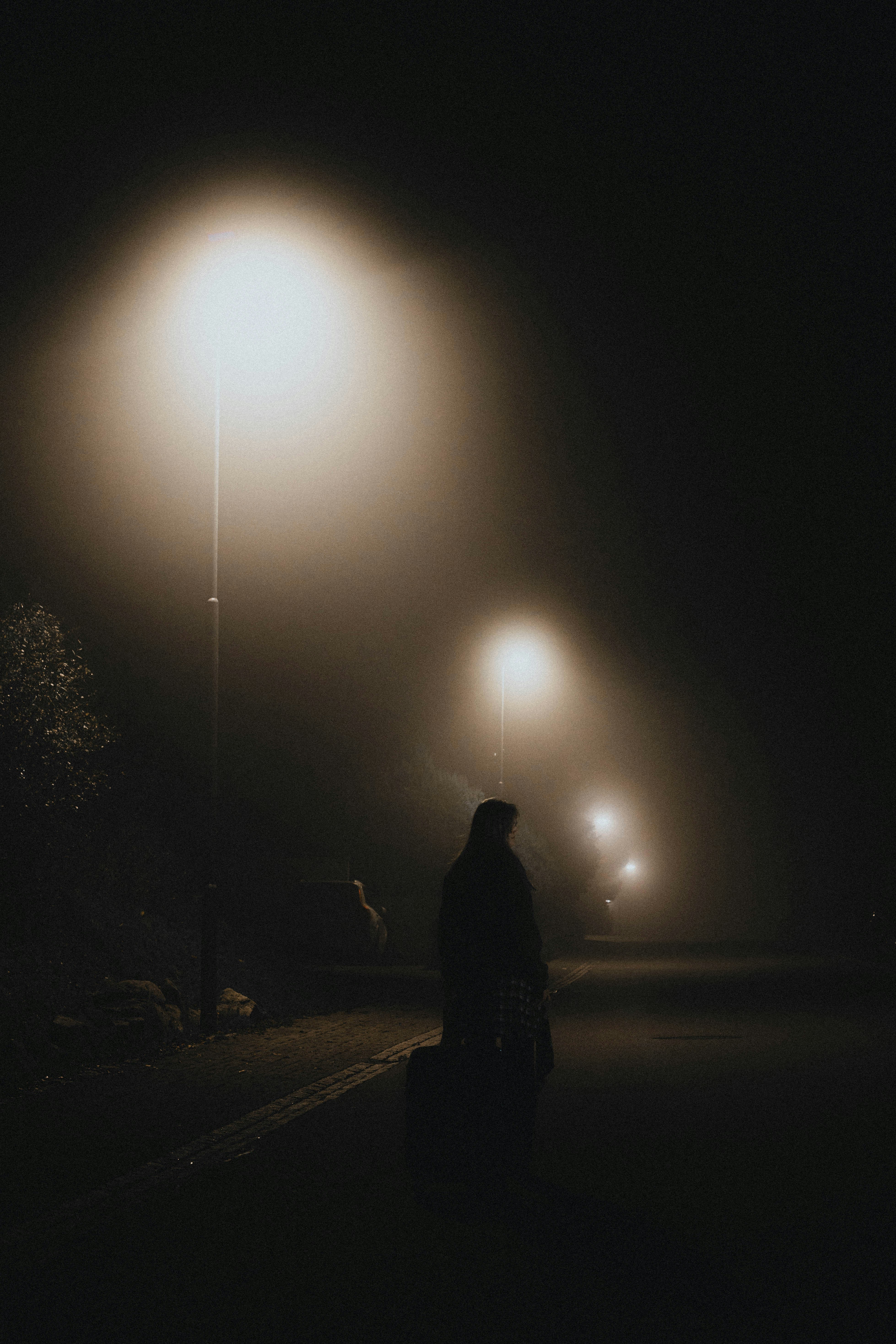 Une femme debout dans une rue la nuit | Source : Unsplash