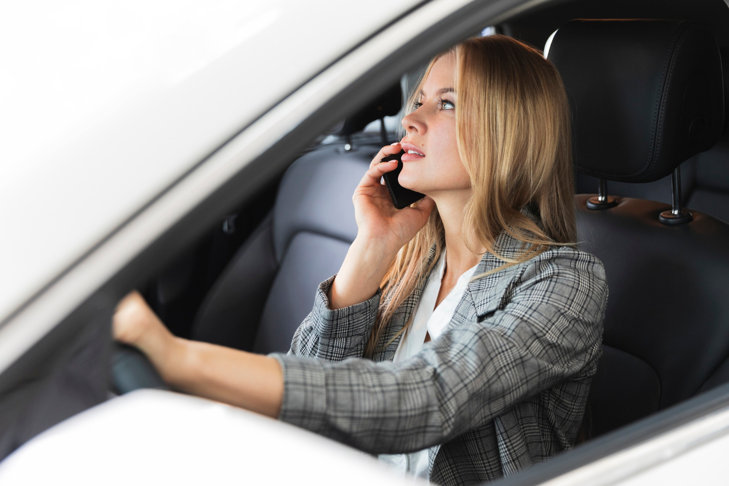 Une femme assise dans sa voiture et parlant au téléphone | Source : Freepik