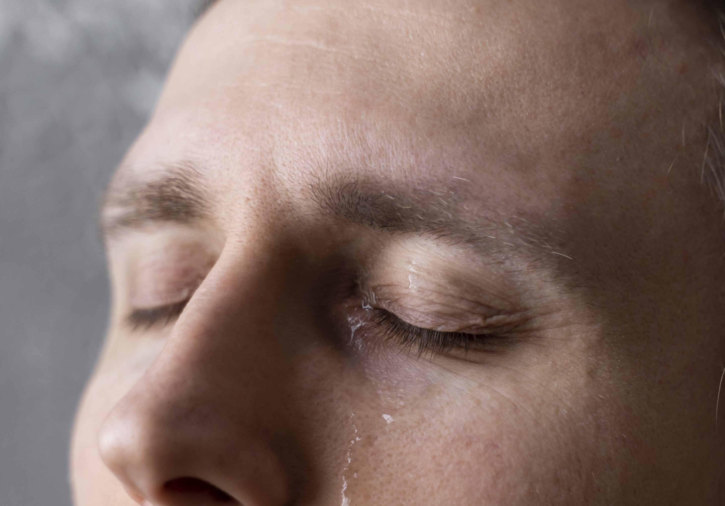 Gros plan d'un homme aux yeux pleins de larmes | Source : Freepik