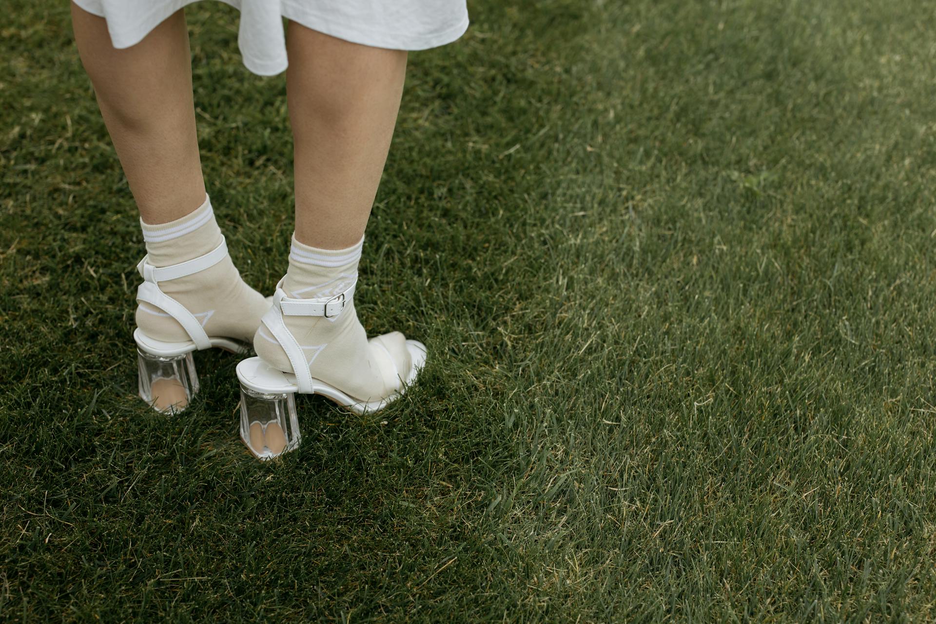 Une femme en talons debout sur l'herbe | Source : Pexels