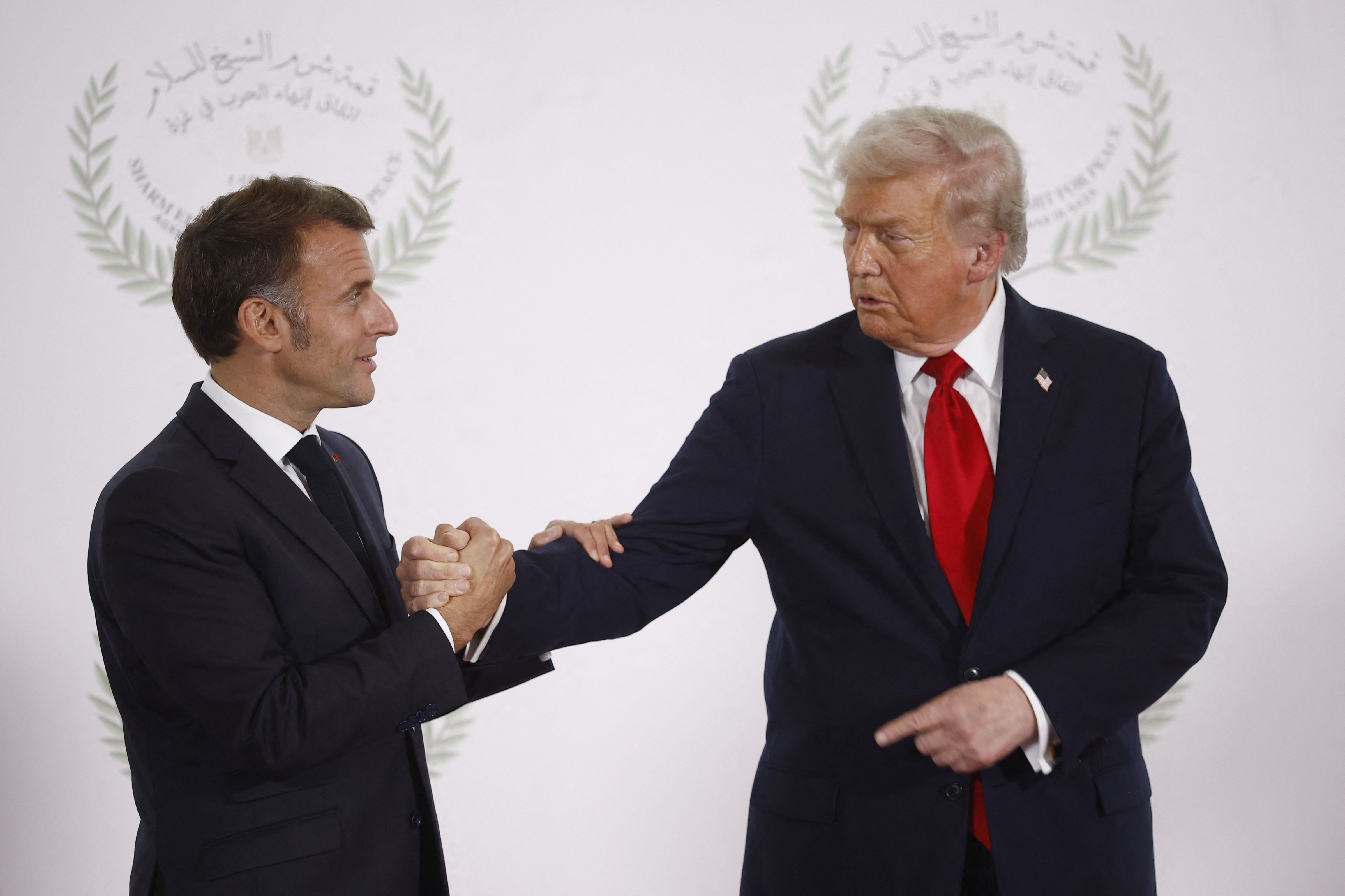 Le président français Emmanuel Macron et le président américain Donald Trump se serrent la main lors du sommet pour la paix à Gaza à Charm el-Cheikh, en Égypte, le 13 octobre 2025 | Source : Getty Images