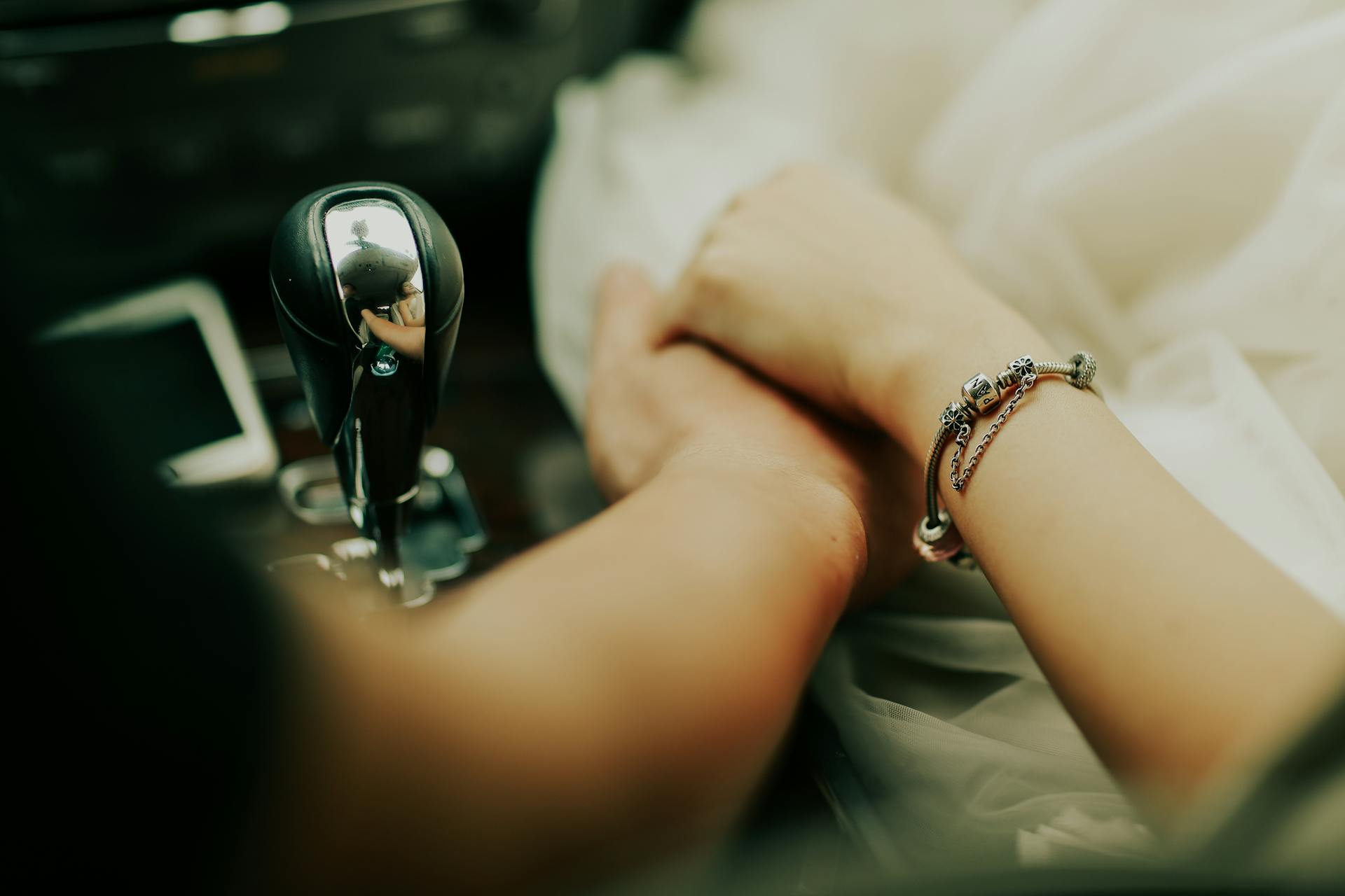 Une femme tenant la main d'un homme assis dans leur voiture | Source : Pexels
