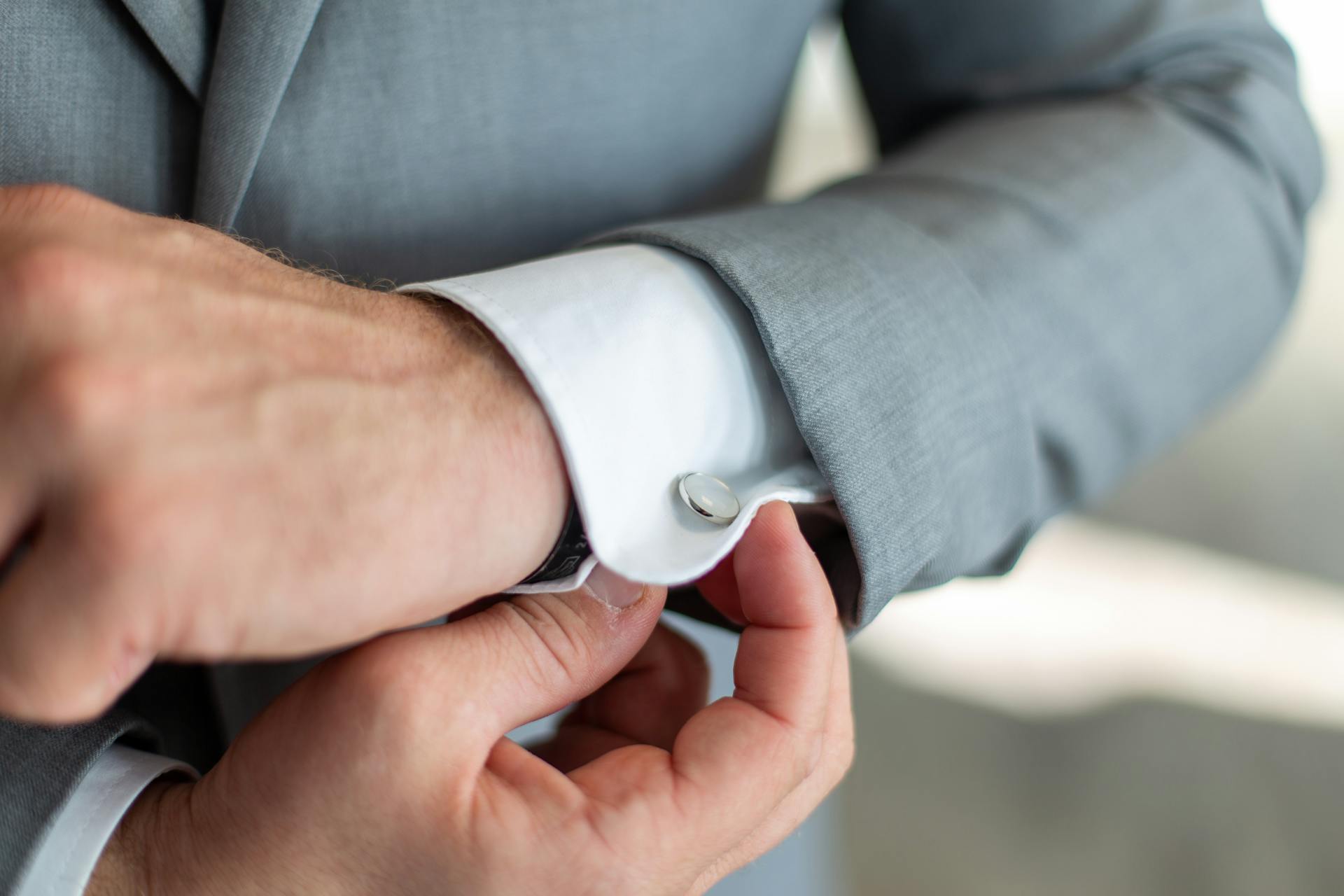 Un homme ajustant son bouton de manchette | Source : Pexels