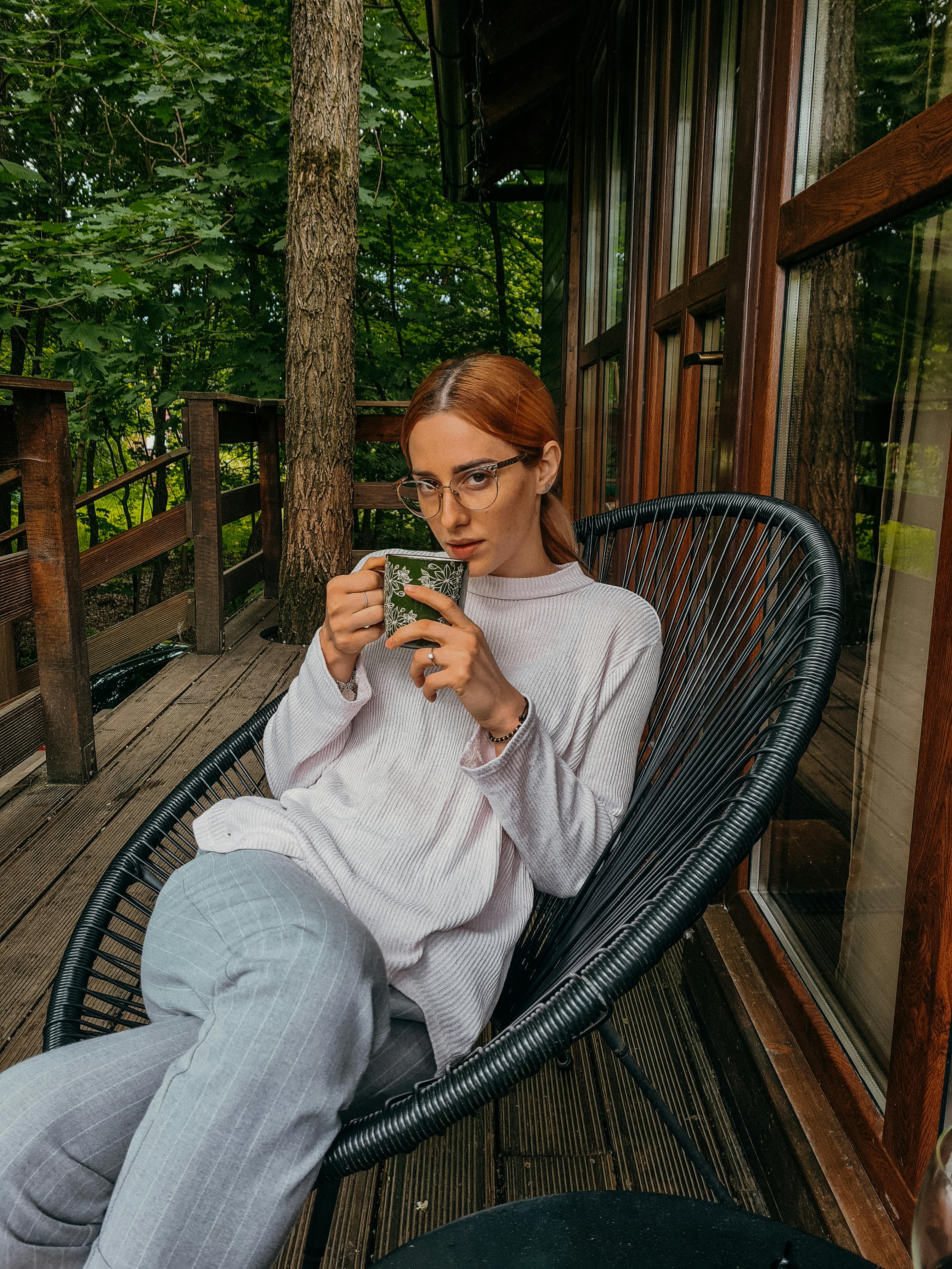 Une femme assise sous son porche avec du thé | Source : Pexels
