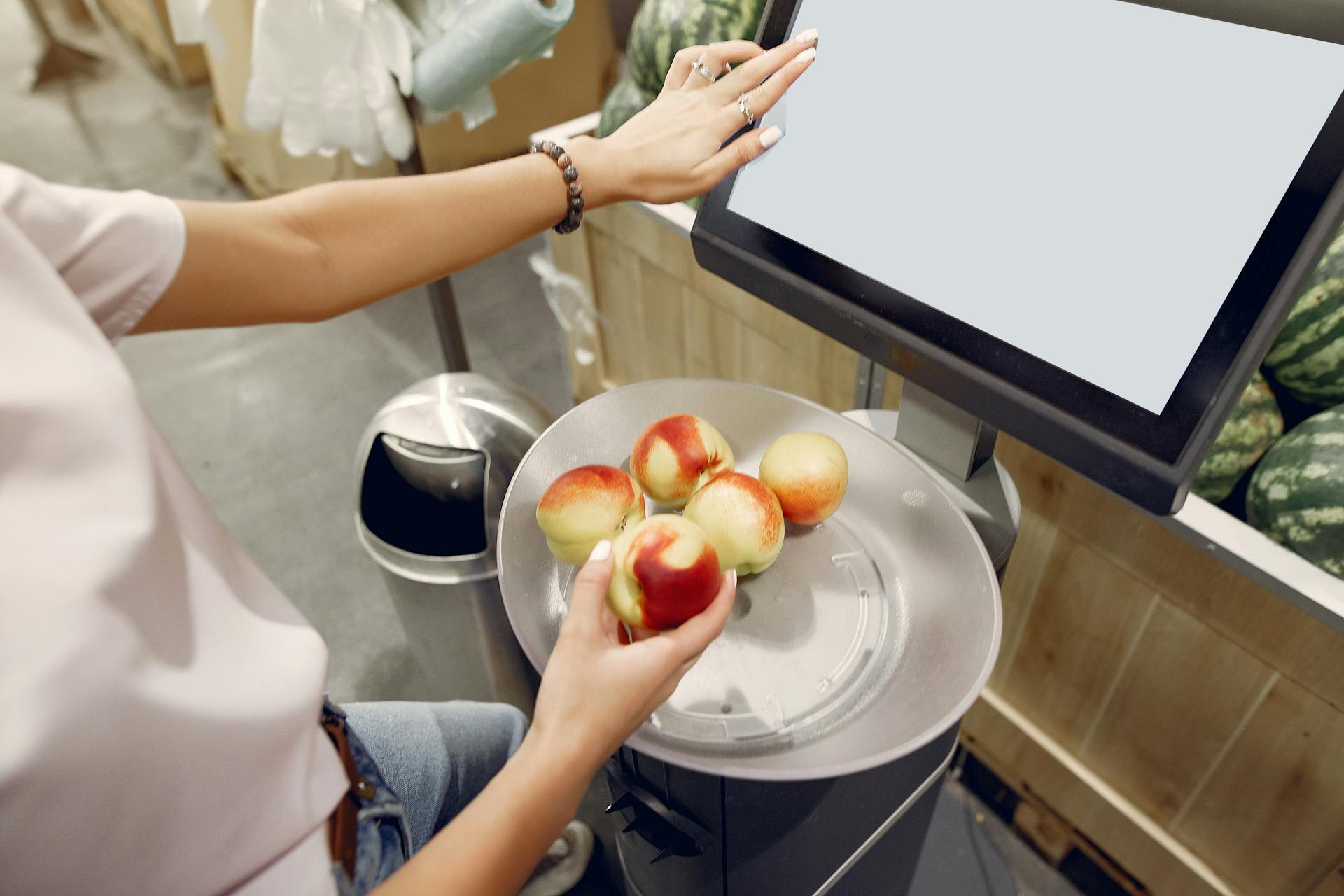 Une femme pesant des pêches sur une balance dans un supermarché | Source : Pexels
