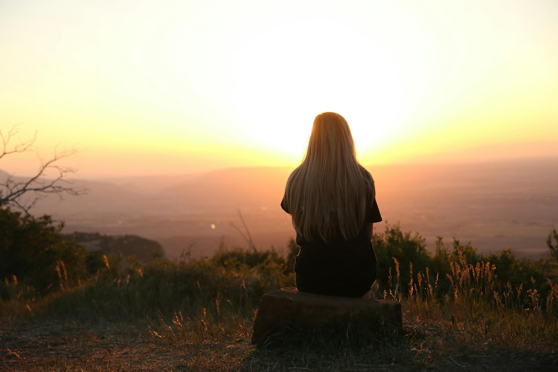 Femme assise sur une montagne profitant de la vue | Source : Pexels