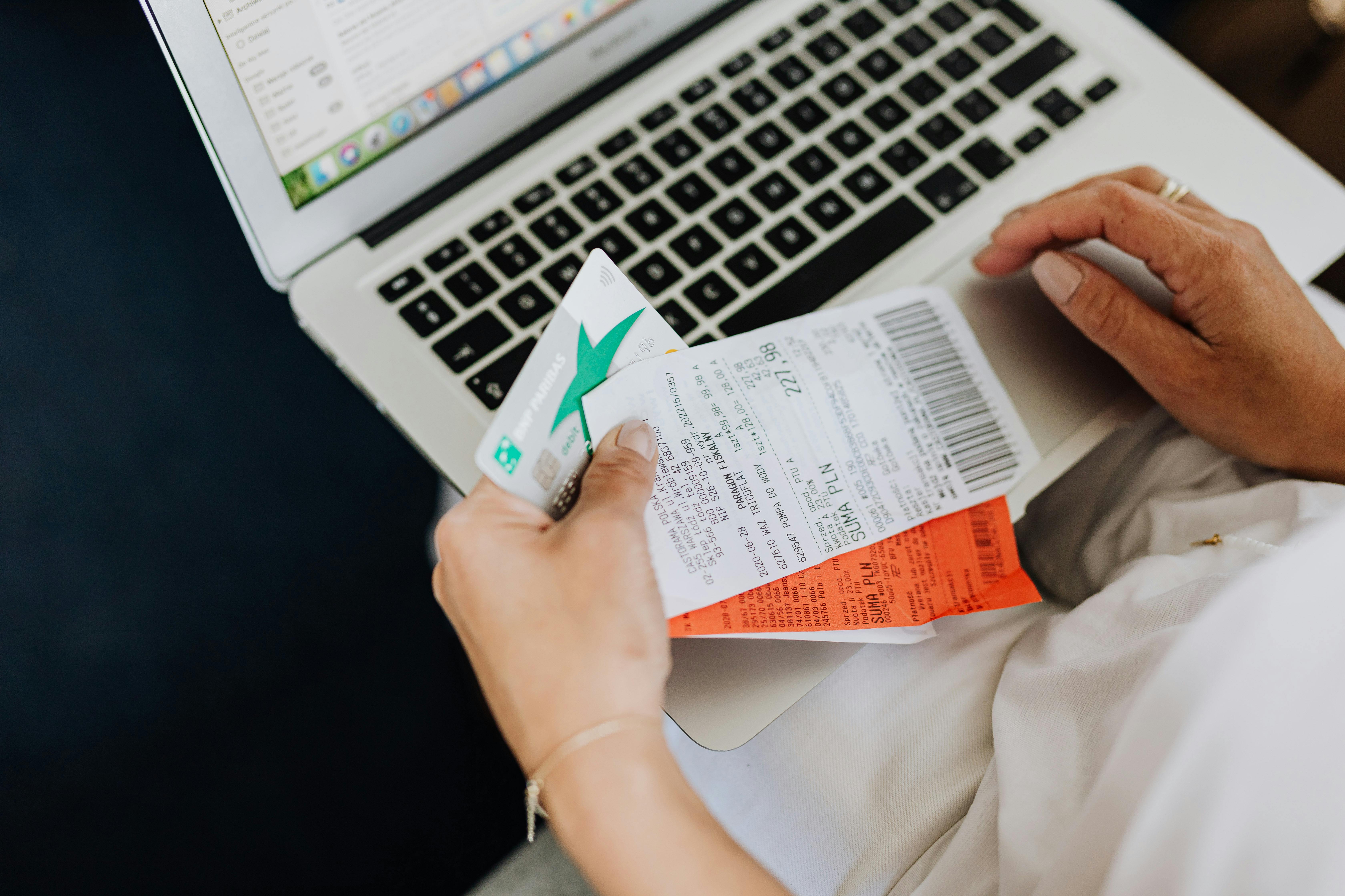 Une femme tenant une carte de crédit et des reçus | Source : Pexels
