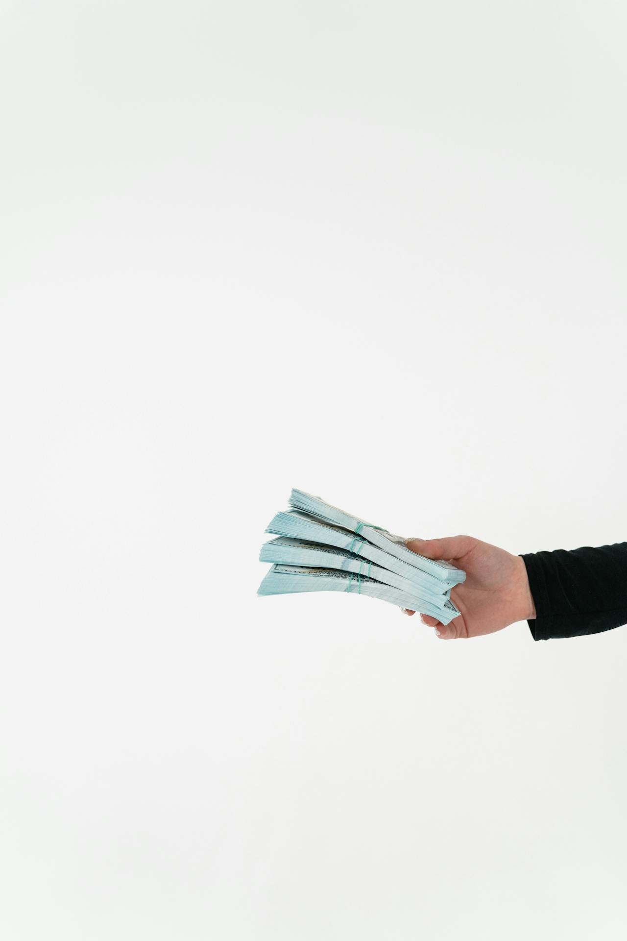 Une femme tenant des liasses de billets | Source : Pexels