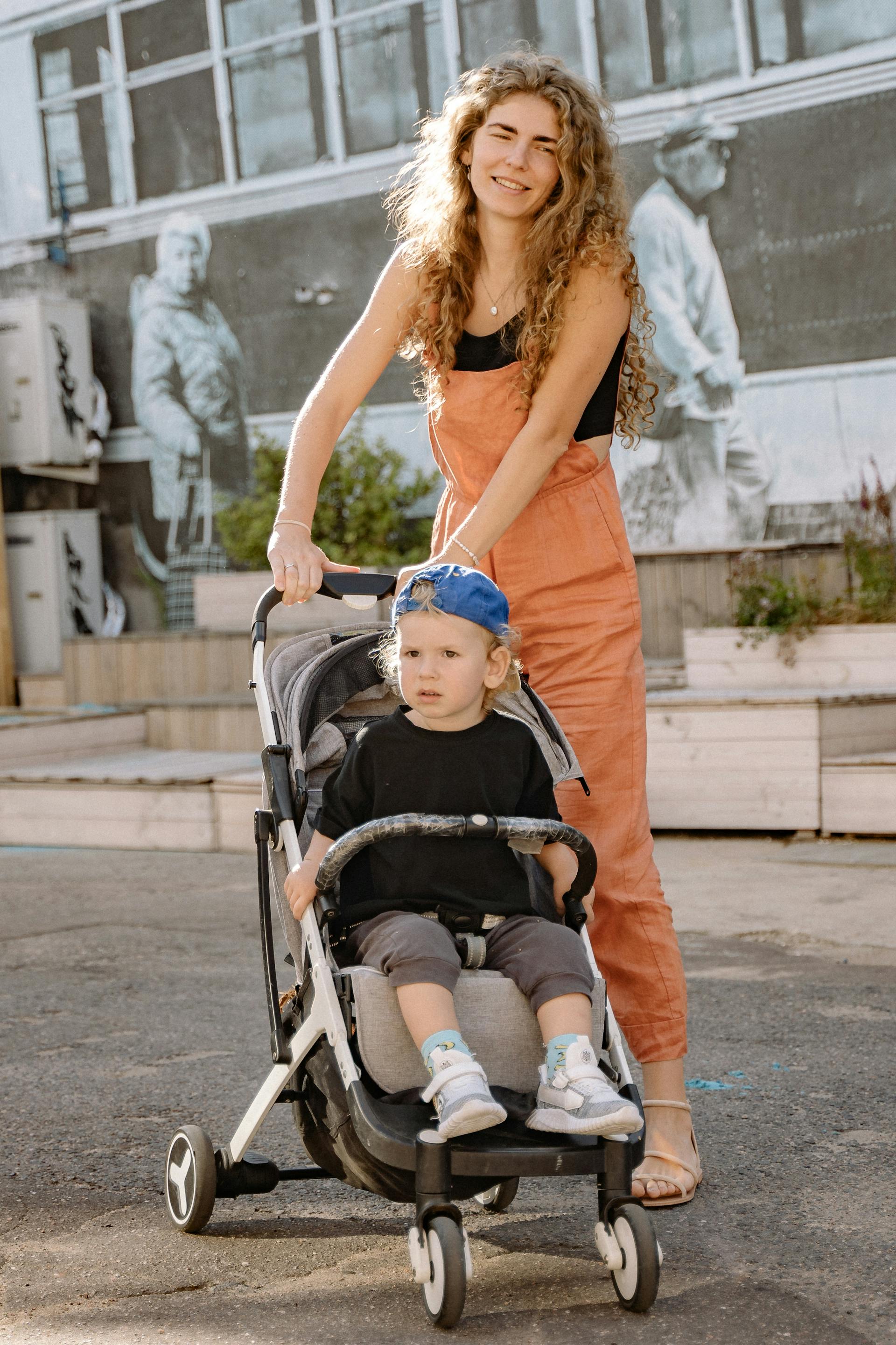 Une femme poussant une poussette avec son fils à l'intérieur | Source : Pexels