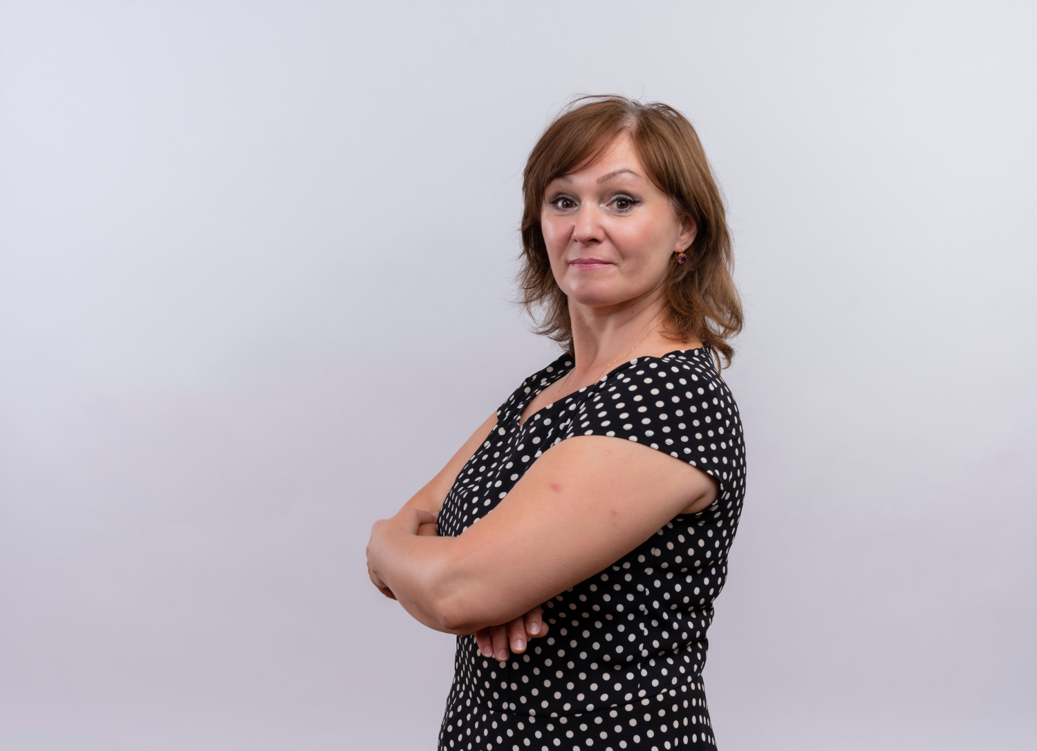 Une femme qui sourit en croisant les bras | Source : Freepik