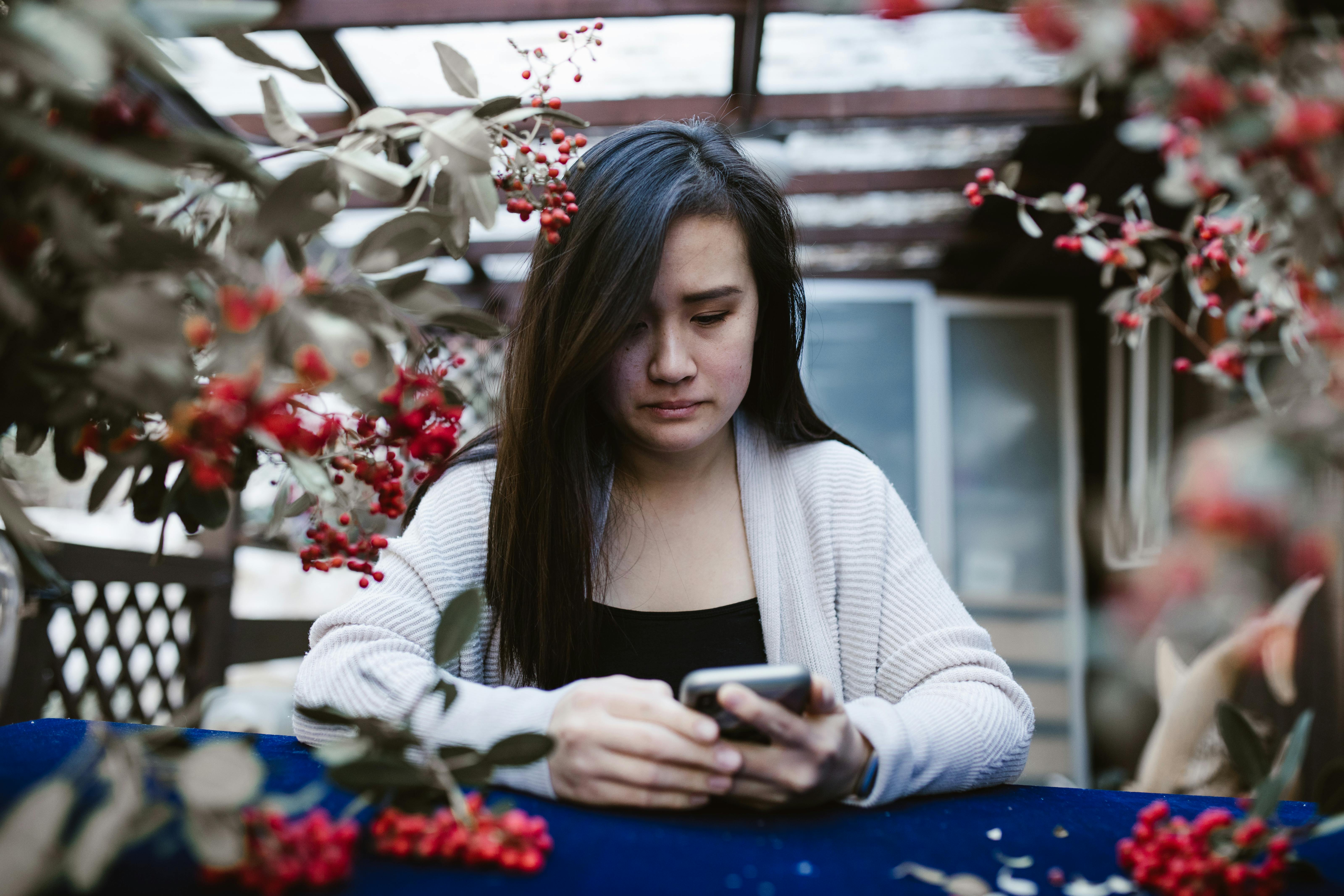 Une femme triste qui regarde son téléphone | Source : Pexels