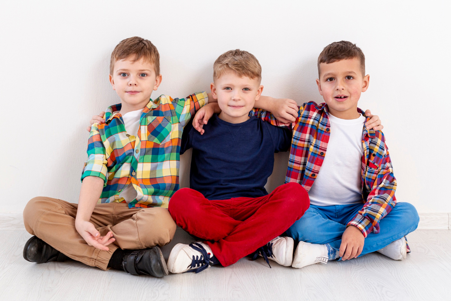 Trois jeunes garçons assis ensemble | Source : Freepik