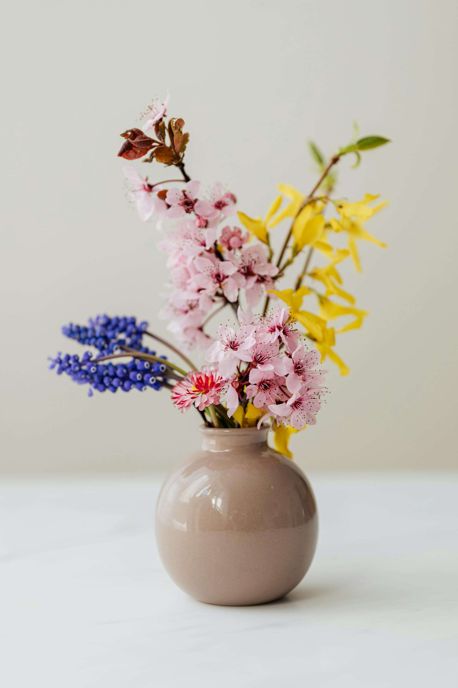 Des fleurs dans un vase en céramique posé sur une table | Source : Pexels