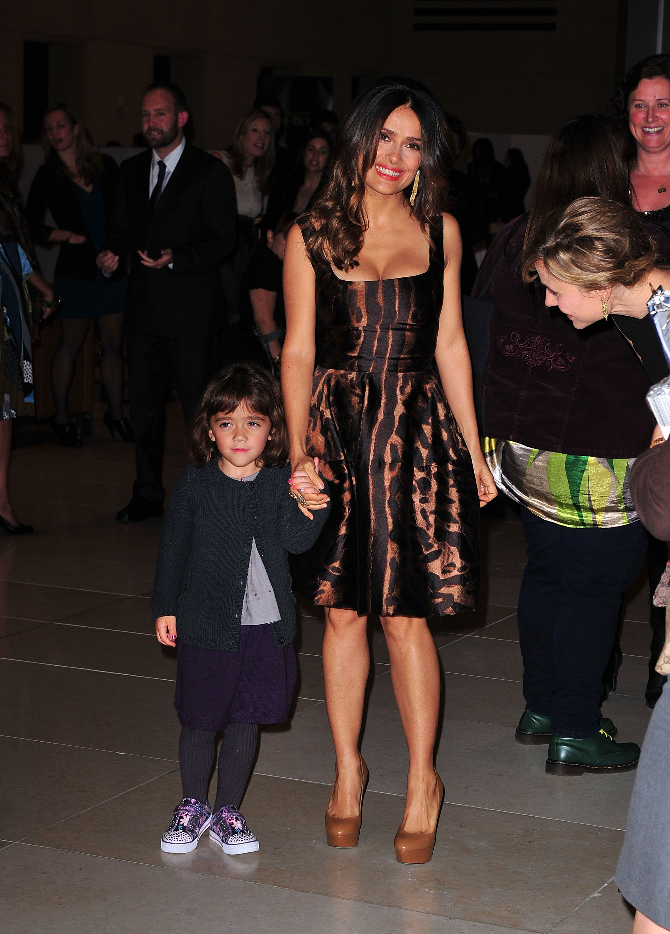 Lors de la projection new-yorkaise du film « Le Chat botté », Salma Hayek et la jeune Valentina Pinault foulent le tapis rouge main dans la main. Salma est resplendissante dans une robe à imprimé animalier et des talons nude vertigineux, tandis que Valentina, vêtue d'un cardigan confortable, d'une jupe violette et de baskets imprimées, semble légèrement timide à côté de sa mère pleine d'assurance.