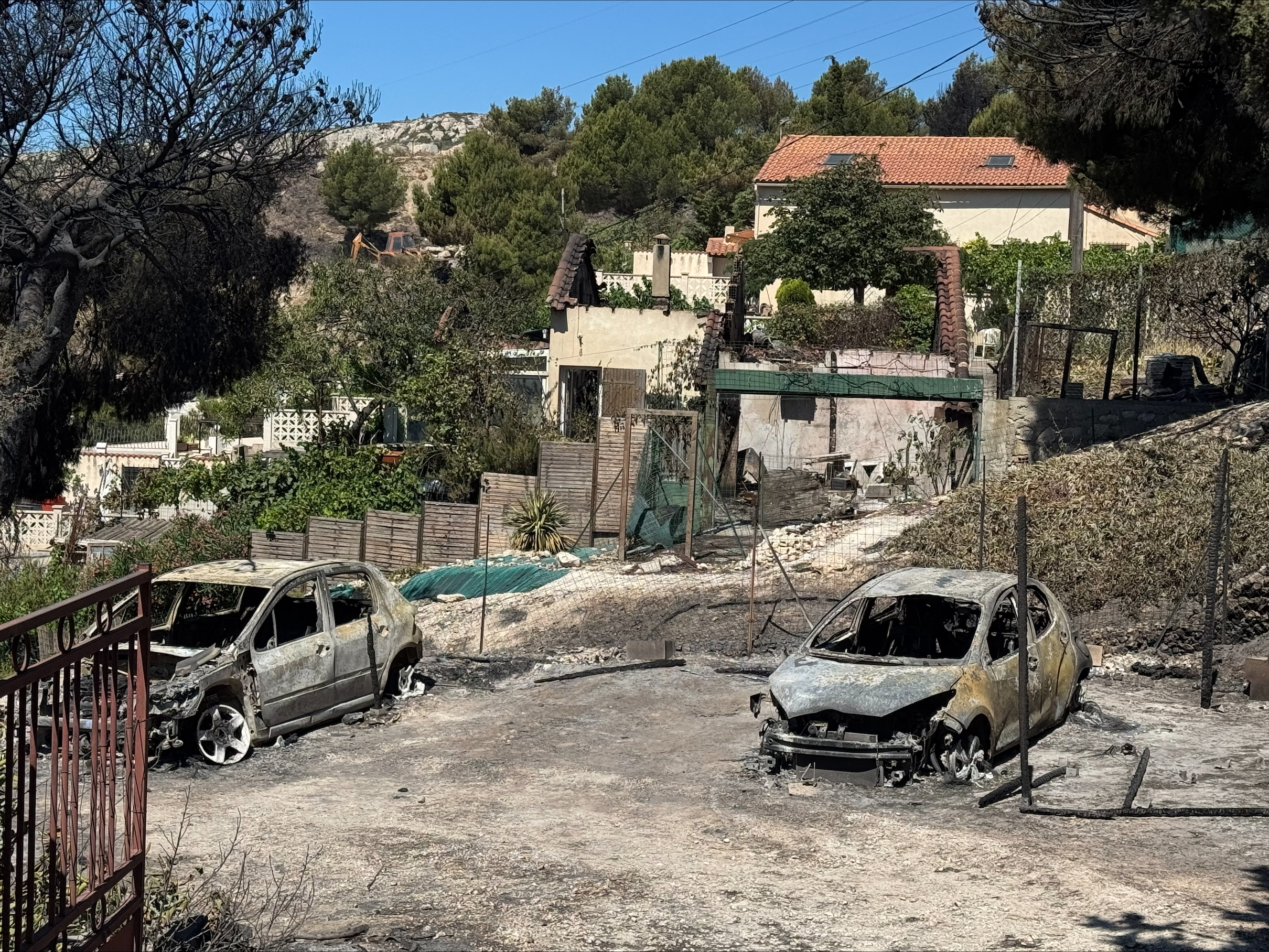 Des véhicules calcinés dans le quartier de Campagne Bleue, dans le district de L'Estaque à Marseille, dans le sud de la France, le 9 juillet 2025, après qu'un incendie a ravagé des zones proches du centre de cette ville portuaire méditerranéenne I Source : Getty Images