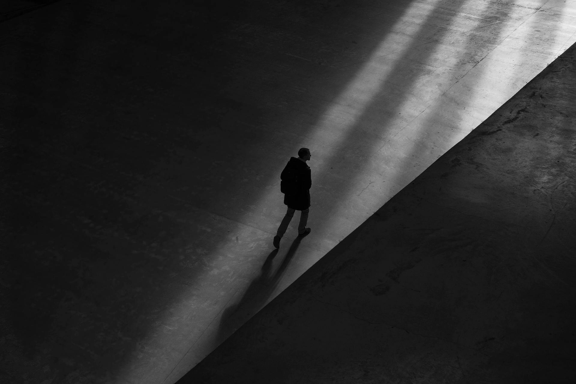 Silhouette en niveaux de gris d'un homme marchant seul | Source : Pexels
