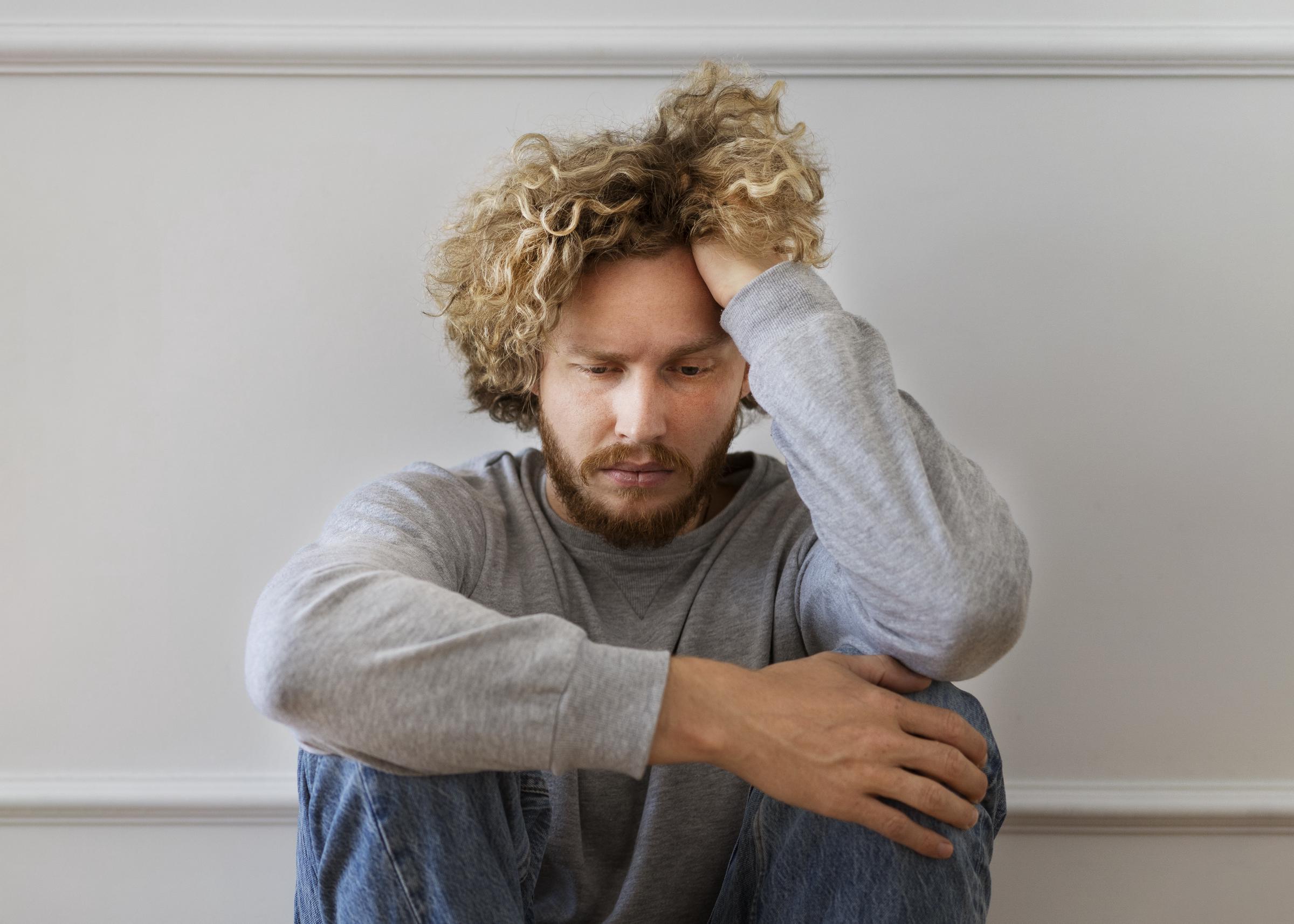 Gros plan sur un homme contrarié portant un pull-over gris | Source : Freepik