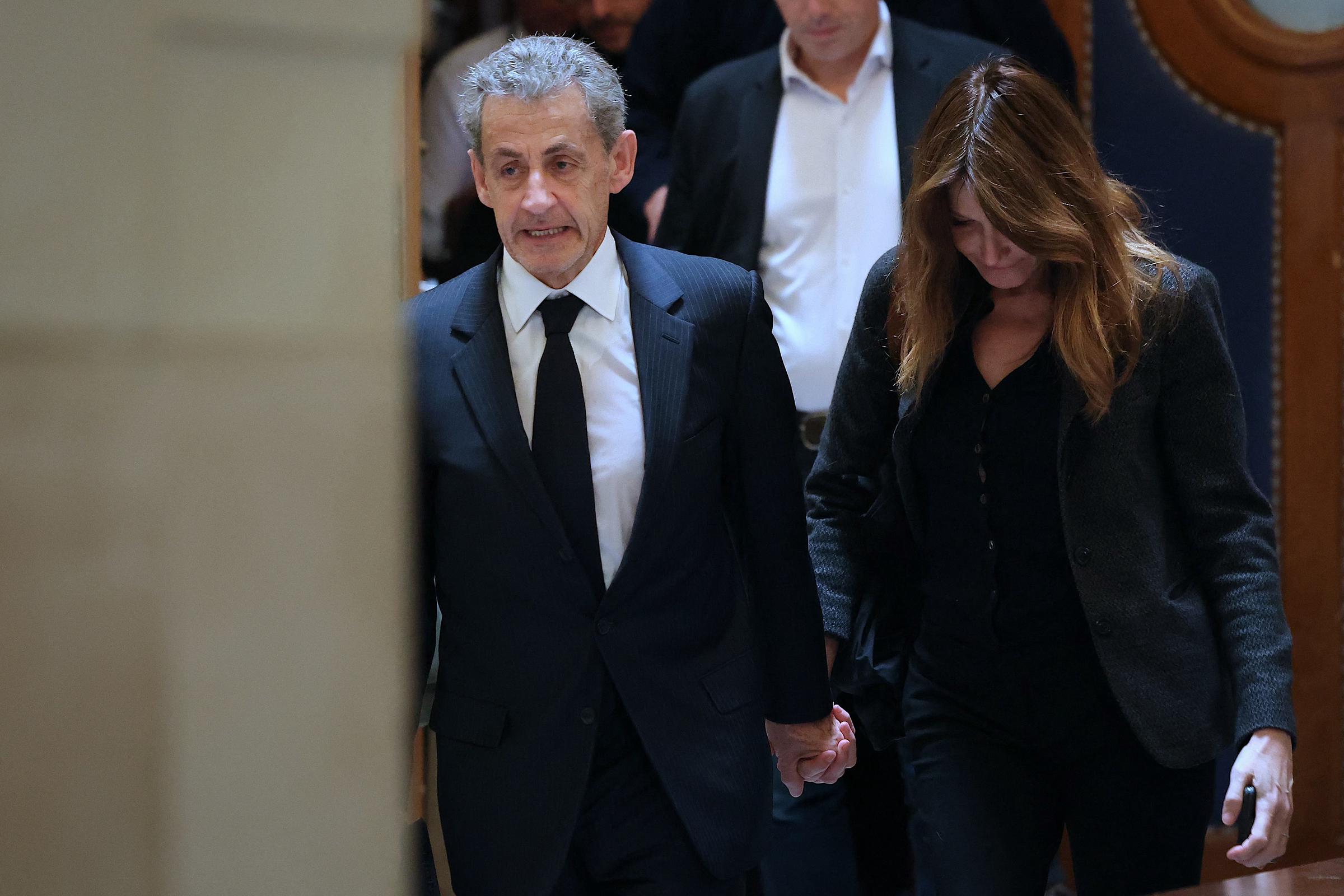 L'ancien président français Nicolas Sarkozy (à gauche) et son épouse Carla Bruni-Sarkozy quittent la salle d'audience après une suspension d'audience lors de son procès en appel concernant les accusations selon lesquelles il aurait sollicité un financement libyen pour sa campagne électorale de 2007, au Palais de Justice de Paris, le 7 avril 2026 I Source : Getty Images