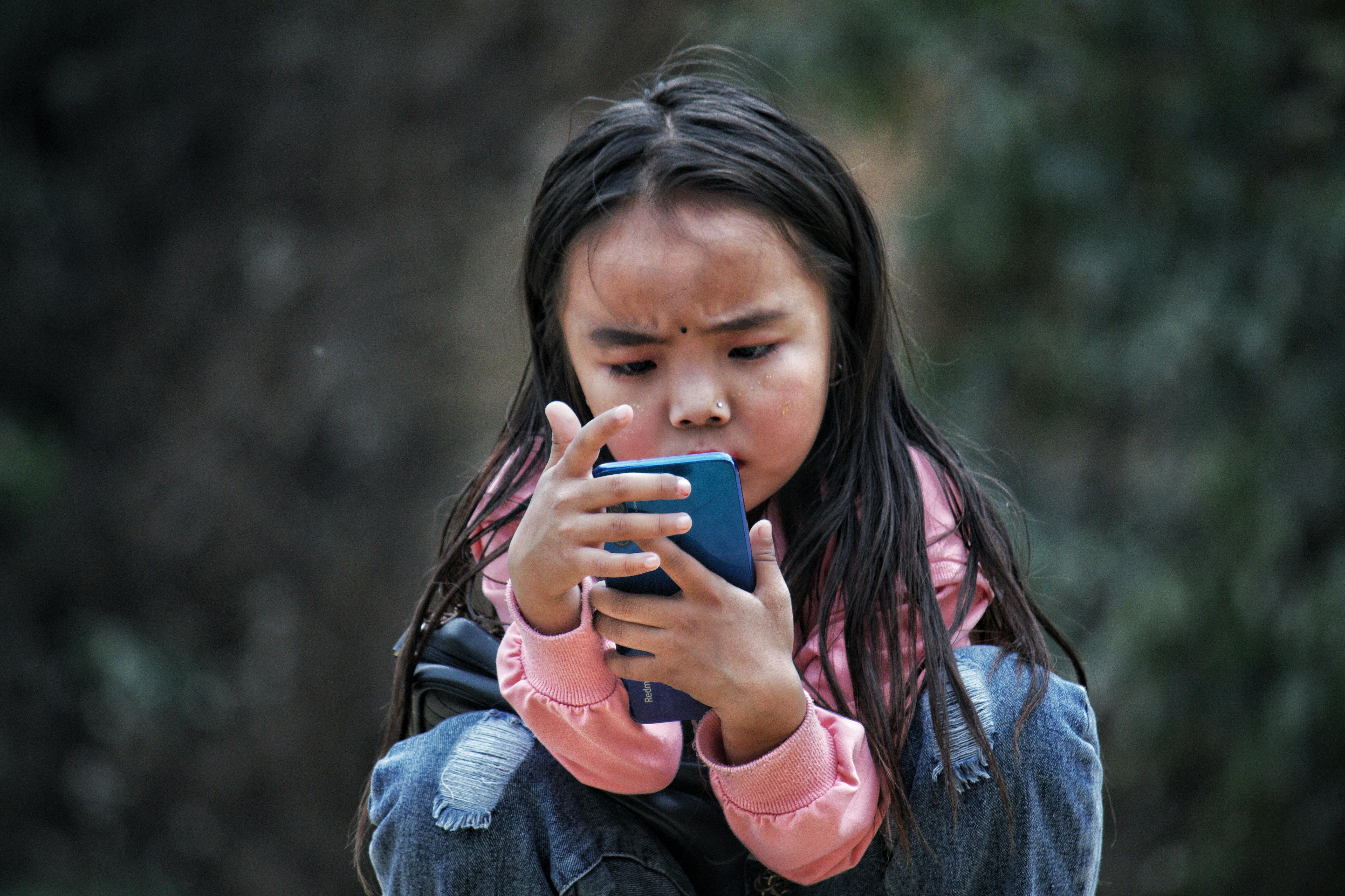 Une petite fille jouant avec un téléphone portable | Source : Pexels