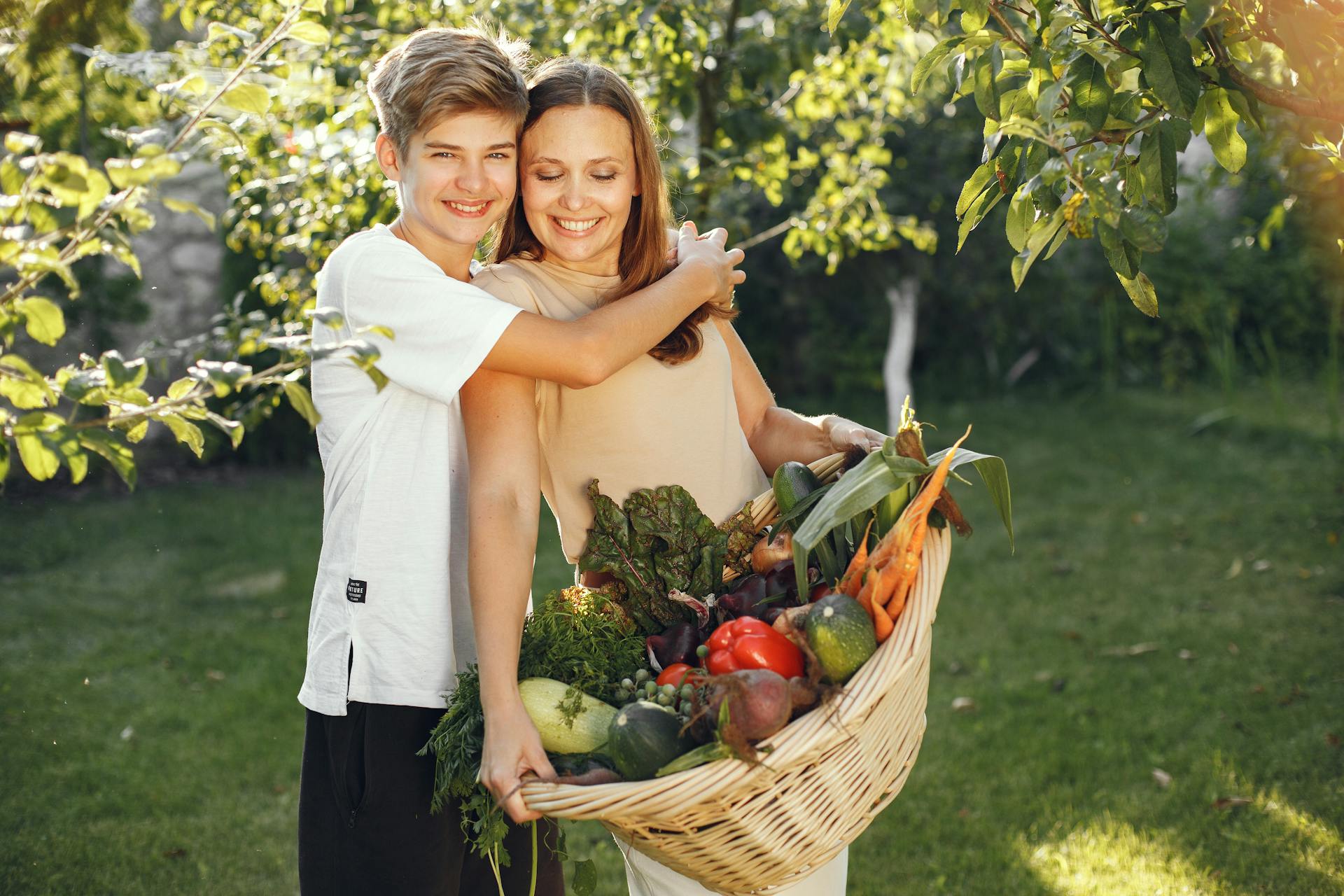 Un garçon qui serre sa maman dans ses bras dans le jardin | Source : Pexels