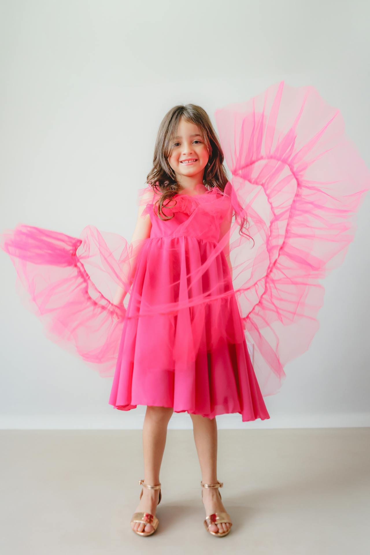 Petite fille excitée dans sa robe rose | Source : Pexels