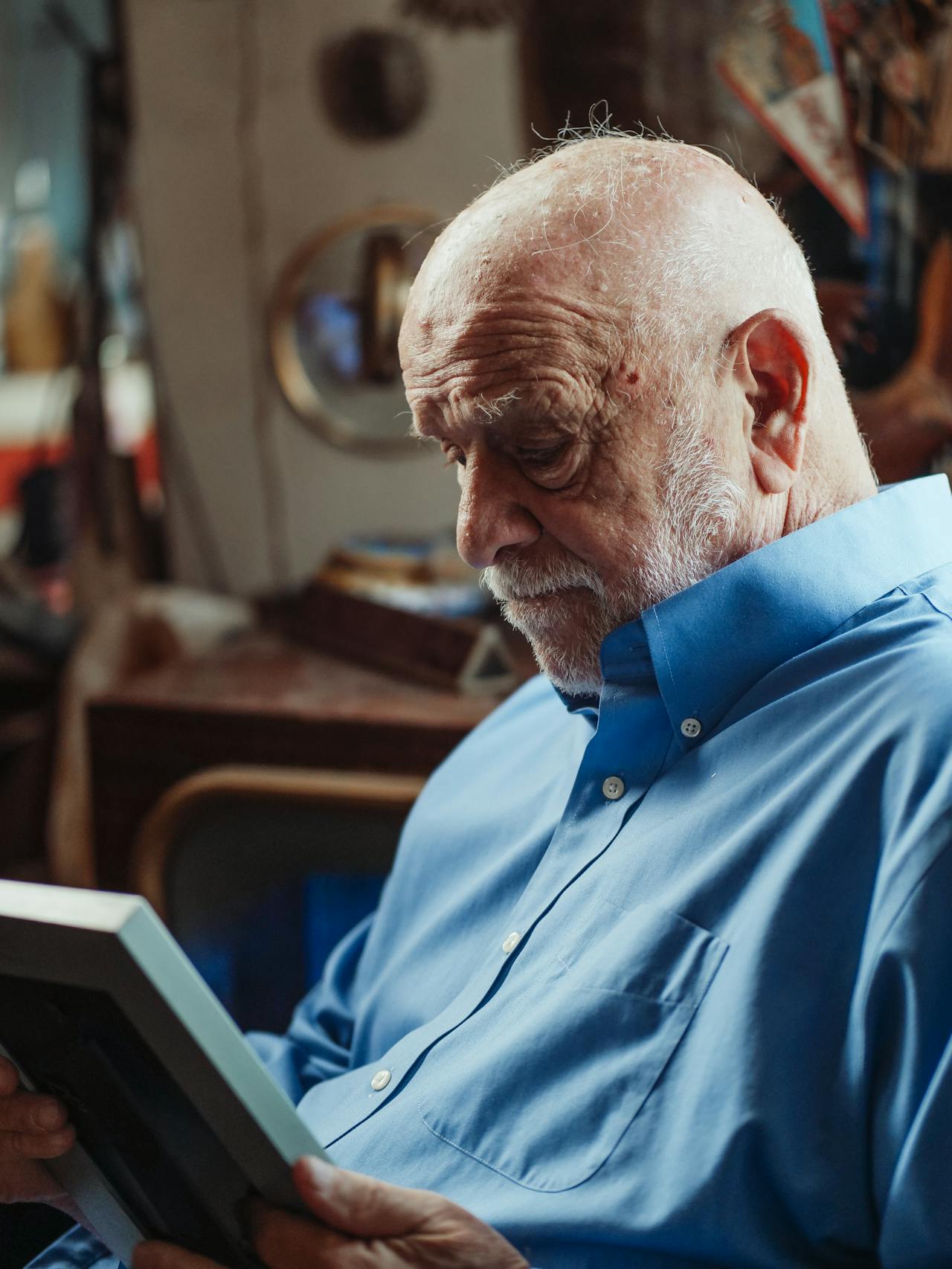 Un homme âgé regardant un cadre photo | Source : Pexels