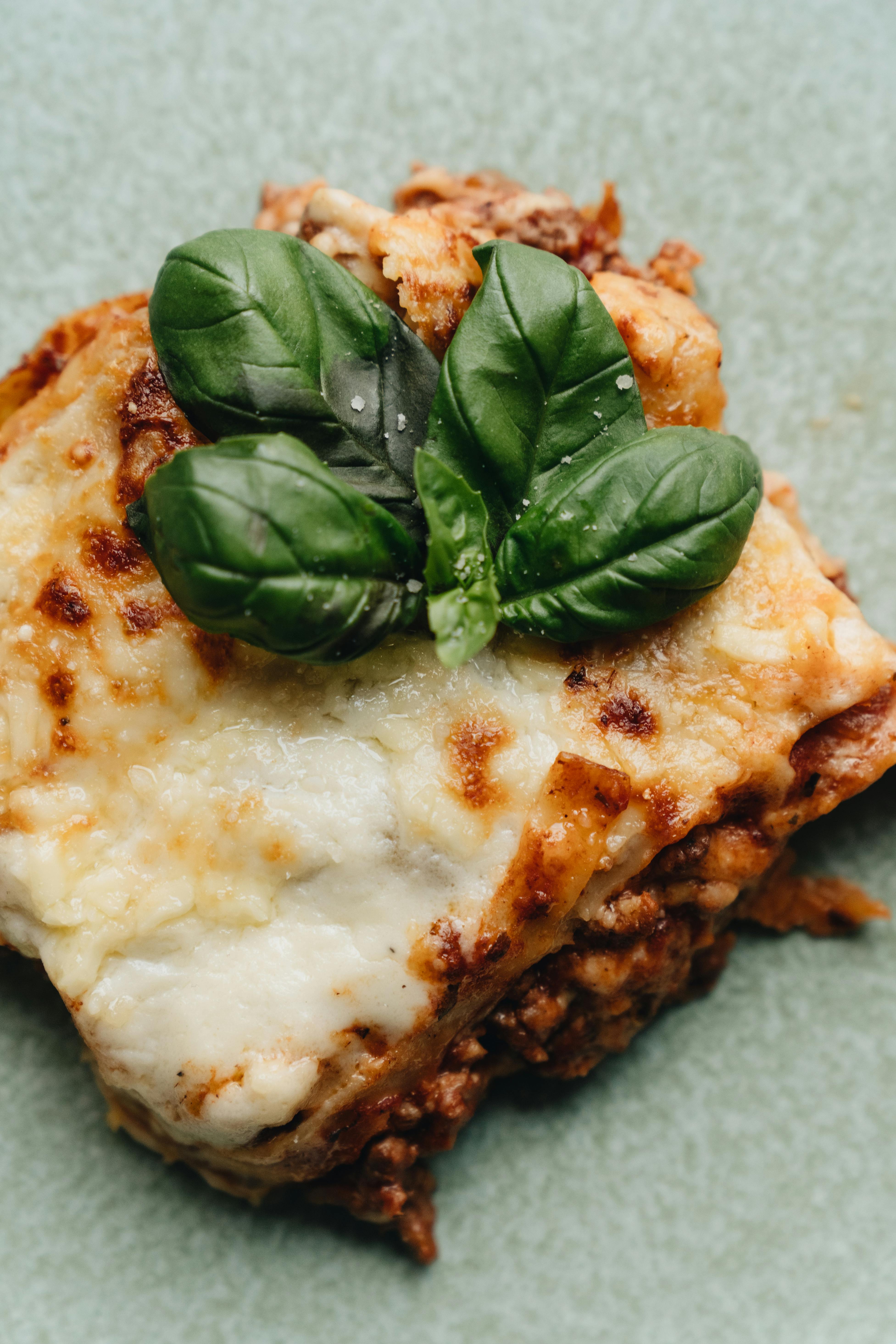 Une tranche de lasagnes garnie de basilic | Source : Pexels