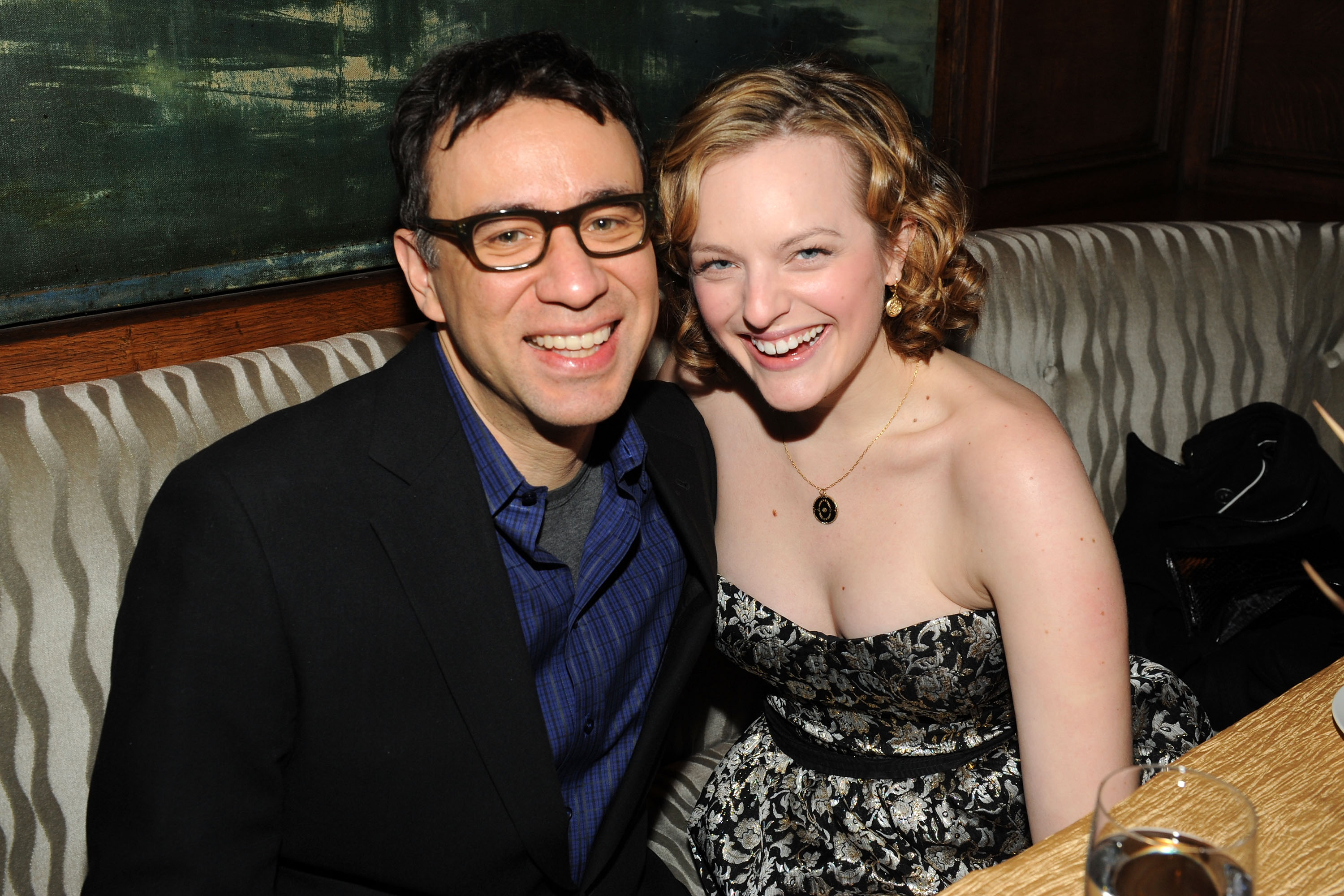Fred Armisen et Elisabeth Moss posent ensemble le 14 décembre 2009 lors de l'after-party organisée après la première du film « Did You Hear About the Morgans? » à New York. Moss porte une robe bustier en brocart noir et argent agrémentée d'accessoires dorés, tandis qu'Armisen sourit dans un blazer sombre et une chemise bleue, assis tout près l'un de l'autre.
