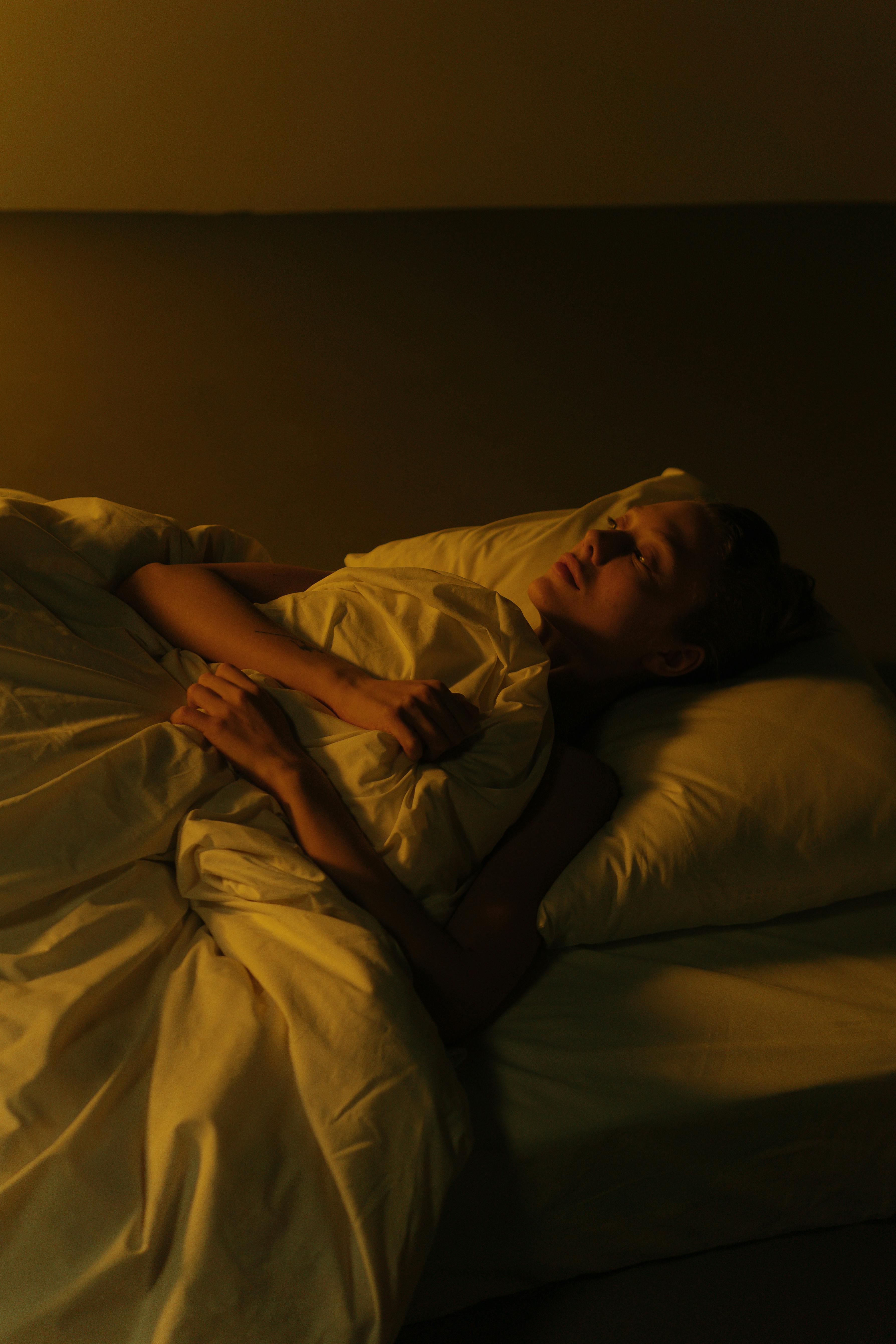 Une femme triste allongée dans son lit | Source : Pexels